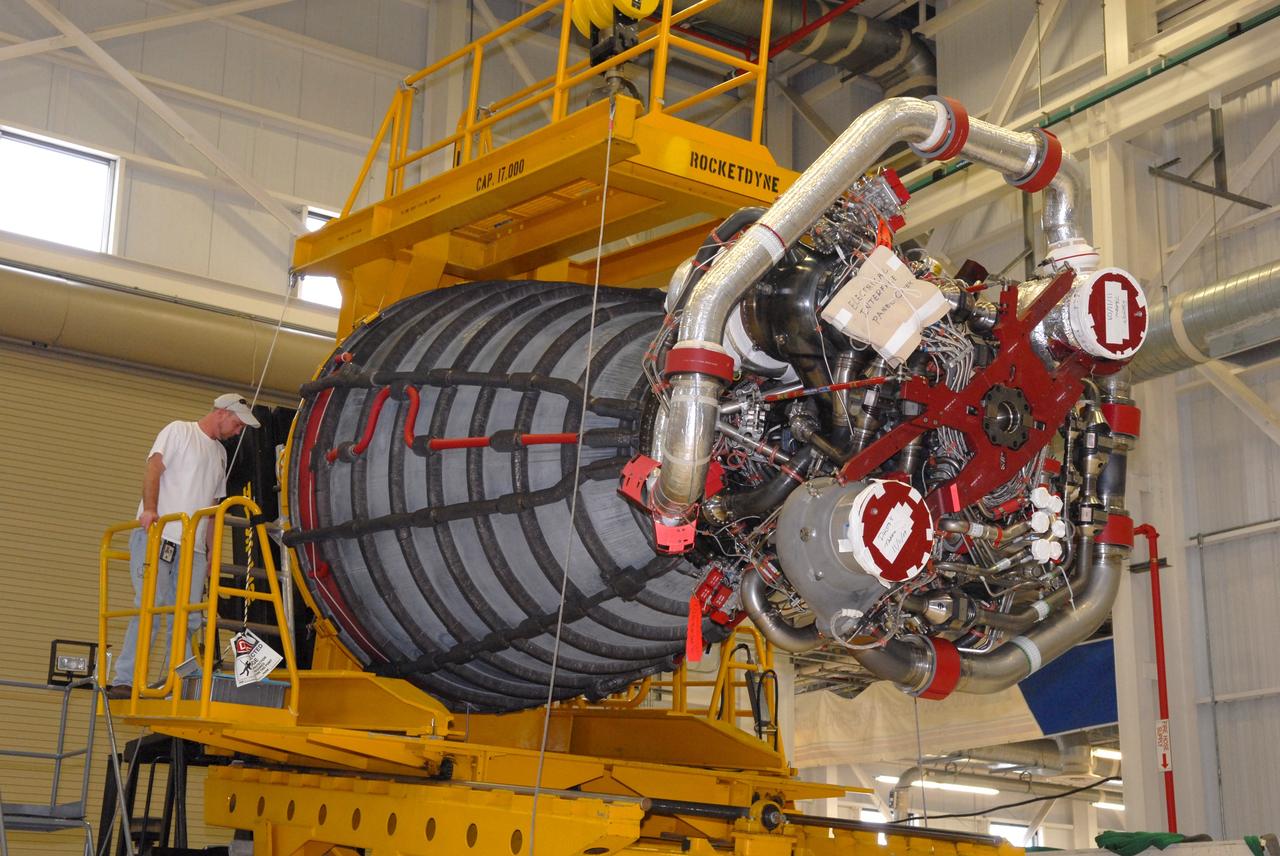 CAPE CANAVERAL, Fla. - In the Space Shuttle Main Engine Processing Facility at NASA's Kennedy Space Center in Florida, a United Space Alliance worker monitors a main engine as it is lowered onto a transporter. The engine is being moved to Orbiter Processing Facility Bay 3 where it will be installed in space shuttle Discovery during processing for the shuttle's STS-131 mission to the International Space Station. The seven-member STS-131 crew will deliver a Multi-Purpose Logistics Module filled with resupply stowage platforms and racks to be transferred to locations around the station. Three spacewalks will include work to attach a spare ammonia tank assembly to the station's exterior and return a European experiment from outside the station's Columbus module. Discovery's launch, targeted for March 18, 2010, will initiate the 33rd shuttle mission to the station. For information on the STS-131 mission and crew, visit http://www.nasa.gov/mission_pages/shuttle/shuttlemissions/sts131/index.html. Photo credit: NASA/Jim Grossmann