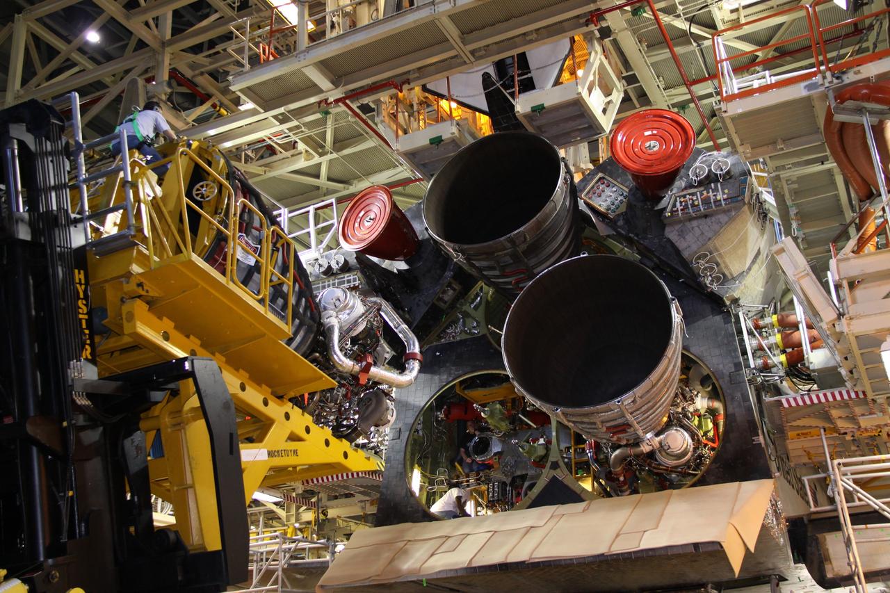 CAPE CANAVERAL, Fla. - In Orbiter Processing Facility Bay 3 at NASA's Kennedy Space Center in Florida, a United Space Alliance worker eases a space shuttle main engine toward shuttle Discovery during installation of the shuttle's engines to support the STS-131 mission to the International Space Station.    The seven-member STS-131 crew will deliver a Multi-Purpose Logistics Module filled with resupply stowage platforms and racks to be transferred to locations around the station.  Three spacewalks will include work to attach a spare ammonia tank assembly to the station's exterior and return a European experiment from outside the station's Columbus module.  Discovery's launch, targeted for March 18, 2010, will initiate the 33rd shuttle mission to the station. For information on the STS-131 mission and crew, visit http://www.nasa.gov/mission_pages/shuttle/shuttlemissions/sts131/index.html.  Photo credit: NASA/Jack Pfaller