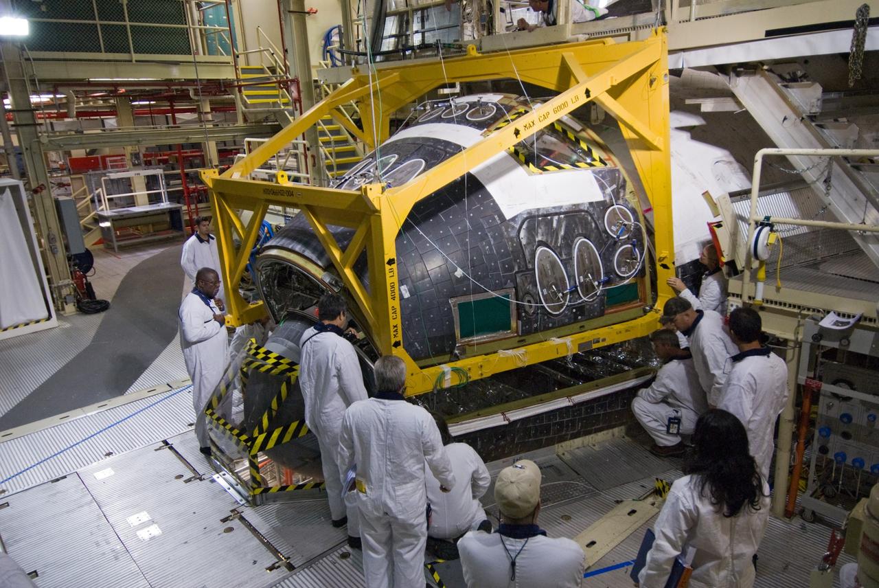 CAPE CANAVERAL, Fla. - In Orbiter Processing Facility Bay 3 at NASA's Kennedy Space Center in Florida, United Space Alliance technicians align space shuttle Discovery's Forward Reaction Control System, or FRCS, into position on the shuttle's frame. The FRCS is being reinstalled in the forward fuselage nose area of the shuttle after refurbishment. The FRCS provides the thrust for attitude (rotational) maneuvers (pitch, yaw and roll) and for small velocity changes along the orbiter axis (translation maneuvers). Discovery is being prepared for the STS-131 mission, the 33rd flight to the International Space Station. The seven-member STS-131 crew will deliver a Multi-Purpose Logistics Module filled with resupply stowage platforms and racks to be transferred to locations around the station. Three spacewalks will include work to attach a spare ammonia tank assembly to the station's exterior and return a European experiment from outside the station's Columbus module. Discovery's launch is targeted for March 18, 2010. For information on the STS-131 mission and crew, visit http://www.nasa.gov/mission_pages/shuttle/shuttlemissions/sts131/index.html. Photo credit: NASA/Amanda Diller