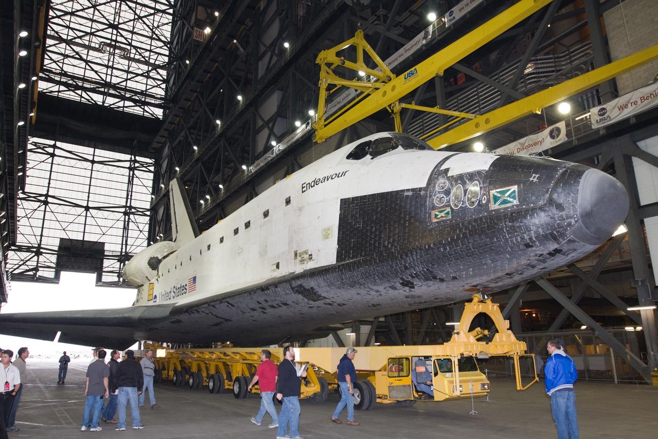 CAPE CANAVERAL, Fla. – At NASA's Kennedy Space Center in Florida, workers prepare to attach a lifting sling on space shuttle Endeavour following its arrival in the Vehicle Assembly Building transfer aisle. The rollover began at 12:53 a.m. EST and was completed at 2:08 p.m. when Endeavour was towed into the VAB's transfer aisle. Next, Endeavour will be attached to the sling, hoisted over a transom and lowered into High Bay 1, where it will be attached to its external fuel tank and solid rocket boosters. Rollout of the shuttle stack to Kennedy’s Launch Pad 39A, a significant milestone in launch processing activities, is planned for early January 2010. The Italian-built Tranquility module, the primary payload for Endeavour's STS-130 mission, will be installed in the payload bay after the shuttle arrives at the pad. Launch is targeted for early February. For information on the STS-130 mission and crew, visit http://www.nasa.gov/mission_pages/shuttle/shuttlemissions/sts130/index.html. Photo credit: NASA/Dimitri Gerondidakis