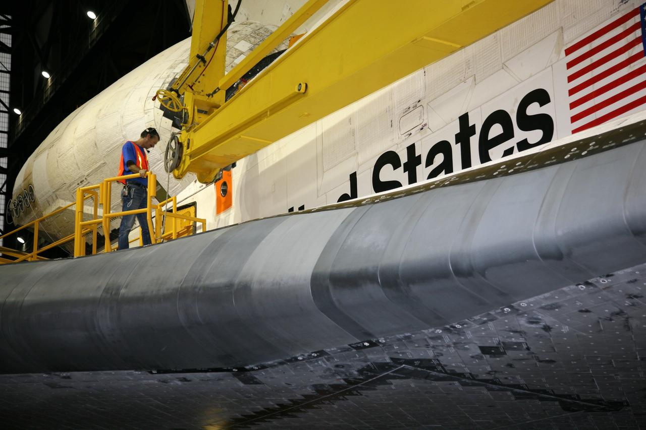 CAPE CANAVERAL, Fla. – In the transfer aisle of the Vehicle Assembly Building at NASA's Kennedy Space Center in Florida, a United Space Alliance technician prepares to attach a lifting sling to space shuttle Endeavour. Next, Endeavour will be hoisted over a transom and lowered into High Bay 1, where it will be attached to its external fuel tank and solid rocket boosters. Rollout of the shuttle stack to Kennedy’s Launch Pad 39A, a significant milestone in launch processing activities, is planned for early January 2010. The Italian-built Tranquility module, the primary payload for Endeavour's STS-130 mission, will be installed in the payload bay after the shuttle arrives at the pad. Launch is targeted for early February. For information on the STS-130 mission and crew, visit http://www.nasa.gov/mission_pages/shuttle/shuttlemissions/sts130/index.html. Photo credit: NASA/Dimitri Gerondidakis