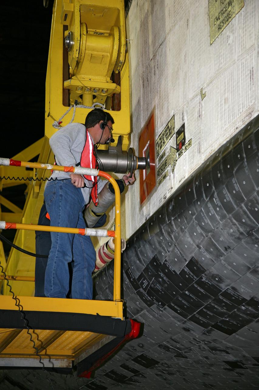 CAPE CANAVERAL, Fla. – In the transfer aisle of the Vehicle Assembly Building at NASA's Kennedy Space Center in Florida, a United Space Alliance technician attaches a lifting sling to space shuttle Endeavour. Next, Endeavour will be hoisted over a transom and lowered into High Bay 1, where it will be attached to its external fuel tank and solid rocket boosters. Rollout of the shuttle stack to Kennedy’s Launch Pad 39A, a significant milestone in launch processing activities, is planned for early January 2010. The Italian-built Tranquility module, the primary payload for Endeavour's STS-130 mission, will be installed in the payload bay after the shuttle arrives at the pad. Launch is targeted for early February. For information on the STS-130 mission and crew, visit http://www.nasa.gov/mission_pages/shuttle/shuttlemissions/sts130/index.html. Photo credit: NASA/Dimitri Gerondidakis