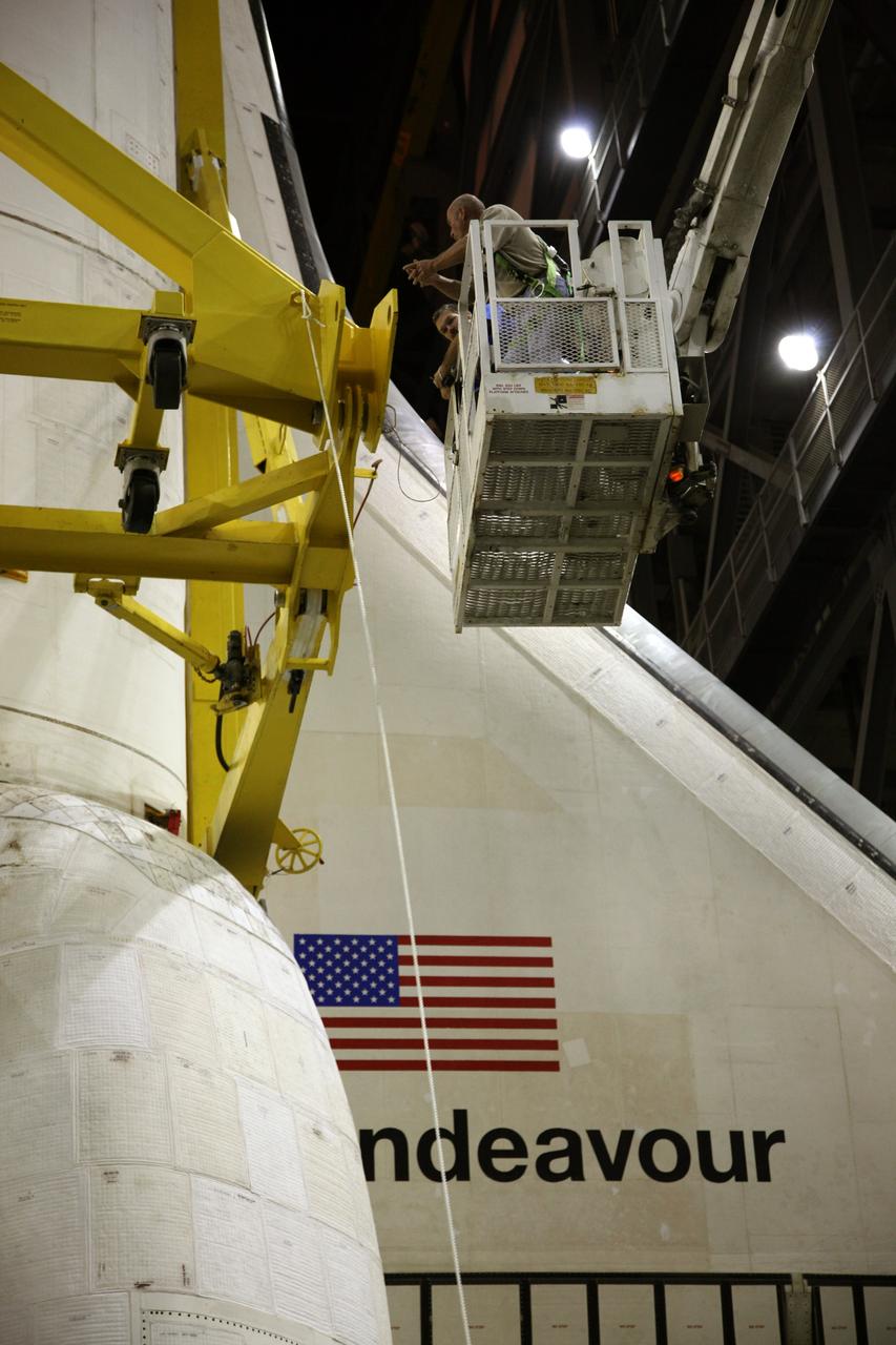 CAPE CANAVERAL, Fla. – In the transfer aisle of the Vehicle Assembly Building at NASA's Kennedy Space Center in Florida, United Space Alliance technicians verify that space shuttle Endeavour is securely attached to the yellow framework of a sling. Next, Endeavour will be hoisted over a transom and lowered into High Bay 1, where it will be attached to its external fuel tank and solid rocket boosters. Rollout of the shuttle stack to Kennedy’s Launch Pad 39A, a significant milestone in launch processing activities, is planned for early January 2010. The Italian-built Tranquility module, the primary payload for Endeavour's STS-130 mission, will be installed in the payload bay after the shuttle arrives at the pad. Launch is targeted for early February. For information on the STS-130 mission and crew, visit http://www.nasa.gov/mission_pages/shuttle/shuttlemissions/sts130/index.html. Photo credit: NASA/Dimitri Gerondidakis
