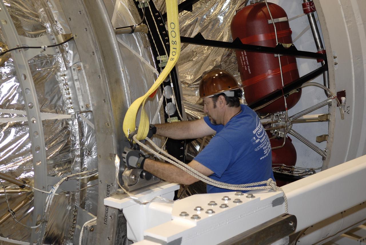 CAPE CANAVERAL, Fla. – In the hangar of the Delta Operations Center at Cape Canaveral Air Force Station in Florida, a worker secures the second stage of a Delta IV rocket to a device that will lift it from a turnover stand following the completion of nozzle extension deployment system testing in the hangar's test cell. The United Launch Alliance Delta IV rocket is slated to launch GOES-P, the latest Geostationary Operational Environmental Satellite developed by NASA for the National Oceanic and Atmospheric Administration, or NOAA. Next, the second stage will be transported to the Horizontal Integration Facility where it will be inspected and prepared for mating with the Delta IV rocket's first stage. GOES-P, a meteorological satellite, is designed to watch for storm development and observed current weather conditions on Earth. Launch of GOES-P is scheduled for no earlier than Feb. 25, 2010, from Launch Complex 37. For information on GOES-P, visit http://goespoes.gsfc.nasa.gov/goes/spacecraft/n_p_spacecraft.html. Photo credit: NASA/Glenn Benson