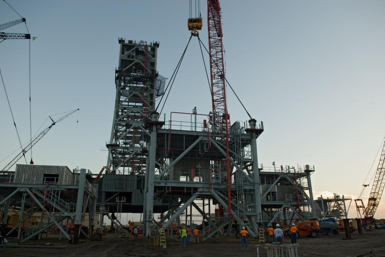 CAPE CANAVERAL, Fla. – At NASA's Kennedy Space Center in Florida, workers monitor the lift of the sixth segment of the tower of a new mobile launcher, or ML, being constructed to support the Constellation Program. When completed, the tower will be approximately 345 feet tall and have multiple platforms for personnel access. The construction is under way at the mobile launcher park site area north of Kennedy's Vehicle Assembly Building. The launcher will provide a base to launch the Ares I rocket, designed to transport the Orion crew exploration vehicle, its crew and cargo to low Earth orbit. Its base is being made lighter than space shuttle mobile launcher platforms so the crawler-transporter can pick up the heavier load of the tower and taller rocket. For information on the Ares I, visit http://www.nasa.gov/ares. Photo credit: NASA/Jim Grossmann
