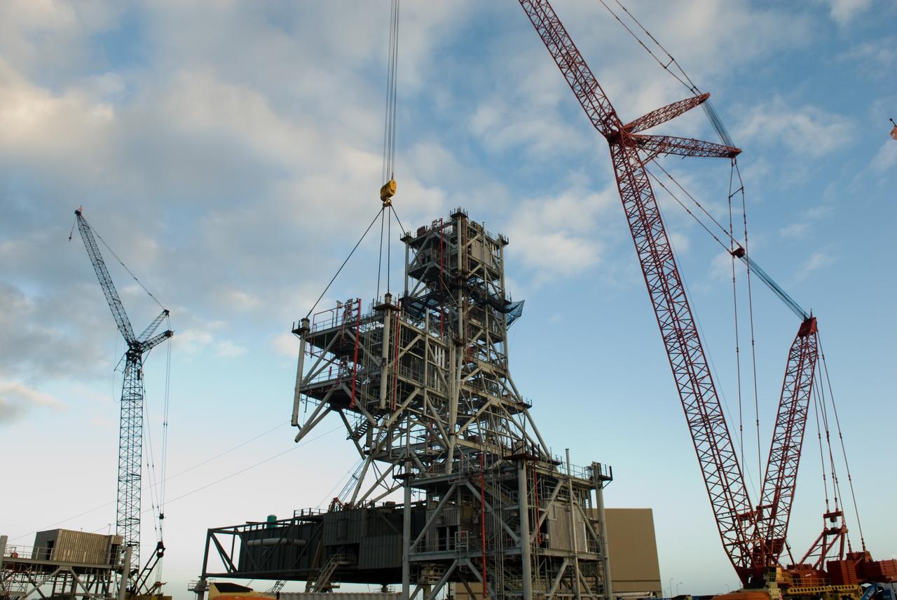 CAPE CANAVERAL, Fla. – At NASA's Kennedy Space Center in Florida, a crane lifts a sixth tower segment toward five segments already secured to a new mobile launcher, or ML, being constructed to support the Constellation Program. When completed, the tower will be approximately 345 feet tall and have multiple platforms for personnel access. The construction is under way at the mobile launcher park site area north of Kennedy's Vehicle Assembly Building. The launcher will provide a base to launch the Ares I rocket, designed to transport the Orion crew exploration vehicle, its crew and cargo to low Earth orbit. Its base is being made lighter than space shuttle mobile launcher platforms so the crawler-transporter can pick up the heavier load of the tower and taller rocket. For information on the Ares I, visit http://www.nasa.gov/ares. Photo credit: NASA/Jim Grossmann