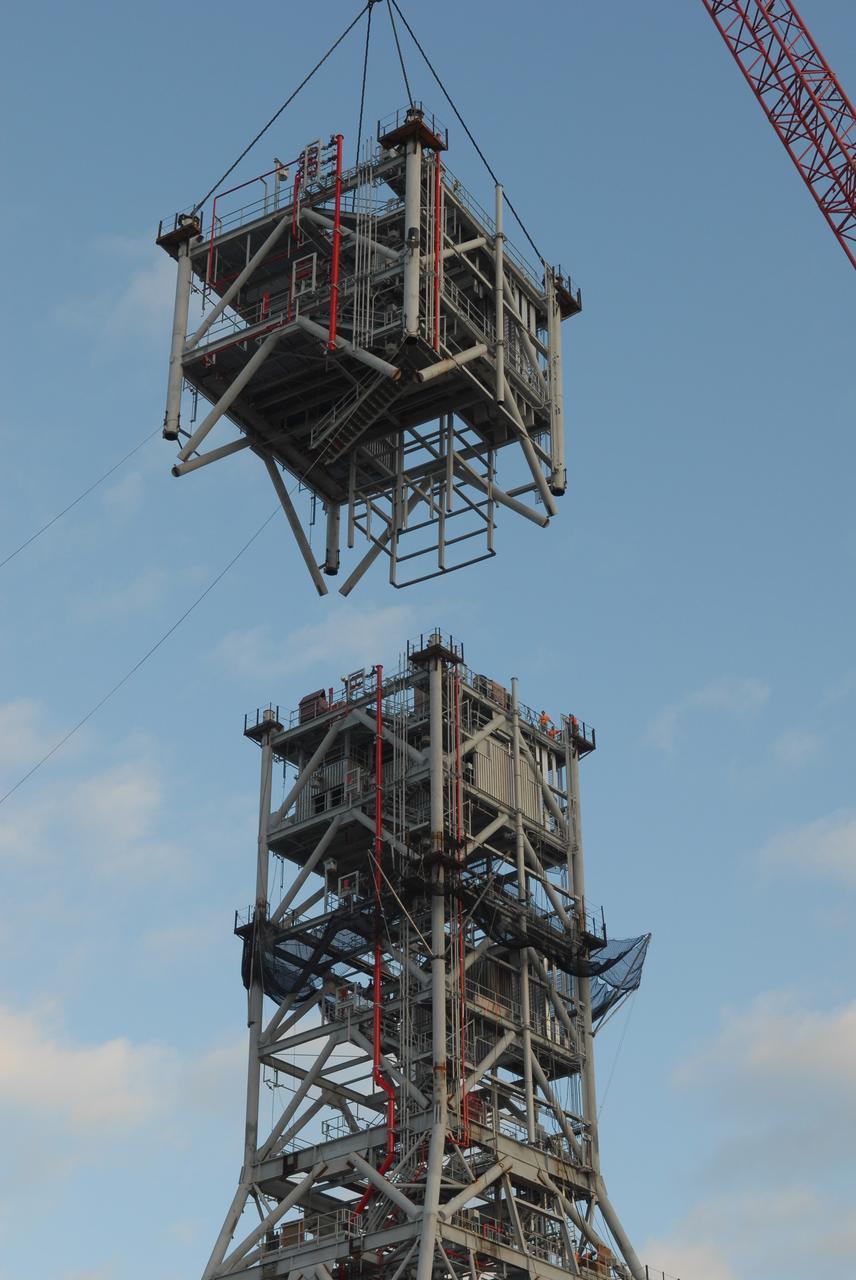 CAPE CANAVERAL, Fla. – At NASA's Kennedy Space Center in Florida, a crane lowers a sixth tower segment onto five segments already secured to a new mobile launcher, or ML, being constructed to support the Constellation Program. When completed, the tower will be approximately 345 feet tall and have multiple platforms for personnel access. The construction is under way at the mobile launcher park site area north of Kennedy's Vehicle Assembly Building. The launcher will provide a base to launch the Ares I rocket, designed to transport the Orion crew exploration vehicle, its crew and cargo to low Earth orbit. Its base is being made lighter than space shuttle mobile launcher platforms so the crawler-transporter can pick up the heavier load of the tower and taller rocket. For information on the Ares I, visit http://www.nasa.gov/ares. Photo credit: NASA/Jim Grossmann