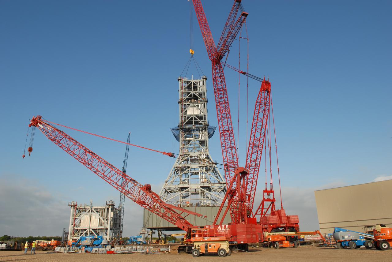 CAPE CANAVERAL, Fla. – At NASA's Kennedy Space Center in Florida, the tower on a new mobile launcher, or ML, for the Constellation Program continues to grow as the sixth tower segment is balanced in position. When completed, the tower will be approximately 345 feet tall and have multiple platforms for personnel access. The construction is under way at the mobile launcher park site area north of Kennedy's Vehicle Assembly Building. The launcher will provide a base to launch the Ares I rocket, designed to transport the Orion crew exploration vehicle, its crew and cargo to low Earth orbit. Its base is being made lighter than space shuttle mobile launcher platforms so the crawler-transporter can pick up the heavier load of the tower and taller rocket. For information on the Ares I, visit http://www.nasa.gov/ares. Photo credit: NASA/Jim Grossmann