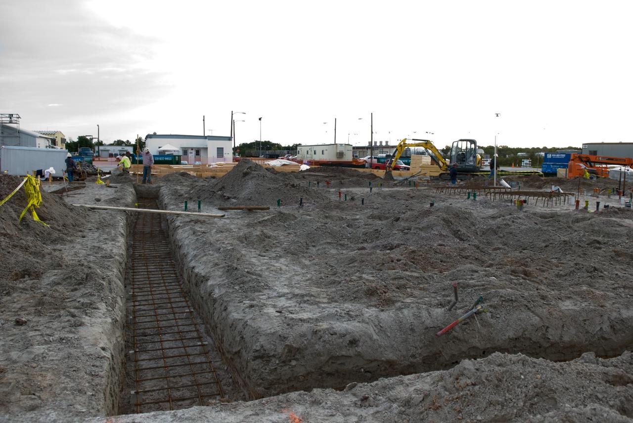 CAPE CANAVERAL, Fla. - Concrete is poured into the trenches that will provide the foundation for the walls of the Propellants North Administrative and Maintenance Facility in Launch Complex 39 at NASA's Kennedy Space Center in Florida.    A tilt-up construction method is being used to erect a THERMOMASS concrete wall insulation system for the facility's walls.  The facility will have a two-story administrative building to house managers, mechanics and technicians who fuel spacecraft at Kennedy adjacent to an 1,800-square-foot single-story shop to store cryogenic fuel transfer equipment.  The new facility will feature high-efficiency roofs and walls, “Cool Dry Quiet” air conditioning with energy recovery technology, efficient lighting, and other sustainable features. The facility is striving to qualify for the U.S. Green Building Council’s Leadership in Energy and Environmental Design, or LEED, Platinum certification. If successful, Propellants North will be the first Kennedy facility to achieve this highest of LEED ratings after it is completed in the summer of 2010.  The facility was designed for NASA by Jones Edmunds and Associates.  Photo credit: NASA/Jim Grossmann