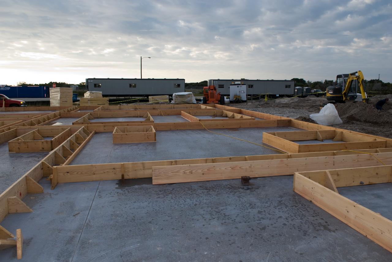 CAPE CANAVERAL, Fla. - Concrete covers the insulation in the walls for the Propellants North Administrative and Maintenance Facility in Launch Complex 39 at NASA's Kennedy Space Center in Florida.    A tilt-up construction method is being used to erect a THERMOMASS concrete wall insulation system for the facility's walls.  In this approach, the exterior layer of concrete for the wall panels is poured and leveled on the building's footprint. Then, prefabricated, predrilled insulation sheets are arranged on top of the unhardened concrete, and connectors, designed to hold the sandwiched layers of concrete and insulation secure, are inserted through the predrilled holes. Next, the structural wythe is poured.  Once cured, these panels are lifted upright to form the building's envelope.  The facility will have a two-story administrative building to house managers, mechanics and technicians who fuel spacecraft at Kennedy adjacent to an 1,800-square-foot single-story shop to store cryogenic fuel transfer equipment.  The new facility will feature high-efficiency roofs and walls, “Cool Dry Quiet” air conditioning with energy recovery technology, efficient lighting, and other sustainable features. The facility is striving to qualify for the U.S. Green Building Council’s Leadership in Energy and Environmental Design, or LEED, Platinum certification. If successful, Propellants North will be the first Kennedy facility to achieve this highest of LEED ratings after it is completed in the summer of 2010.  The facility was designed for NASA by Jones Edmunds and Associates.  Photo credit: NASA/Jim Grossmann