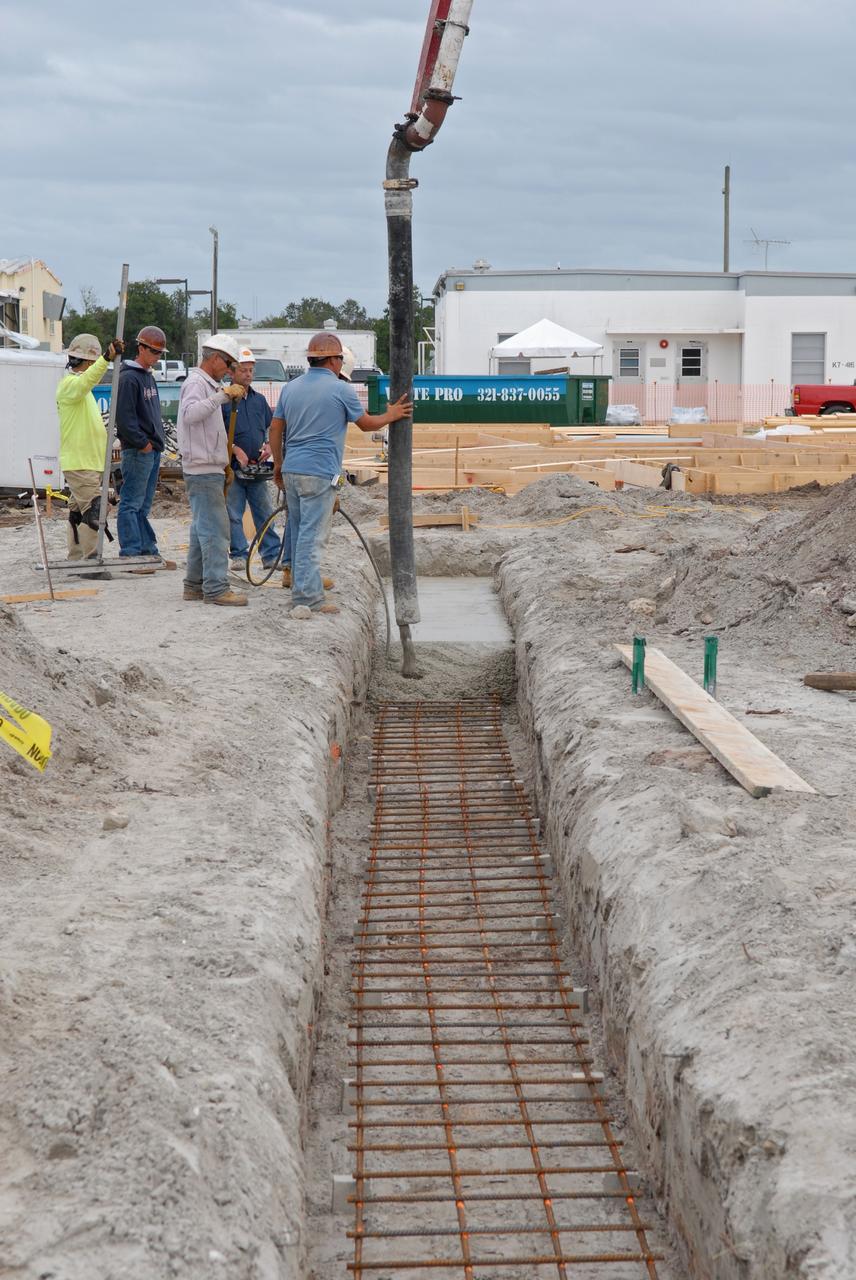 CAPE CANAVERAL, Fla. - Insulation is placed in the walls for the Propellants North Administrative and Maintenance Facility in Launch Complex 39 at NASA's Kennedy Space Center in Florida.    A tilt-up construction method is being used to erect a THERMOMASS concrete wall insulation system for the facility's walls.  In this approach, the exterior layer of concrete for the wall panels is poured and leveled on the building's footprint. Then, prefabricated, predrilled insulation sheets are arranged on top of the unhardened concrete, and connectors, designed to hold the sandwiched layers of concrete and insulation secure, are inserted through the predrilled holes. Next, the structural wythe is poured.  Once cured, these panels are lifted upright to form the building's envelope.  The facility will have a two-story administrative building to house managers, mechanics and technicians who fuel spacecraft at Kennedy adjacent to an 1,800-square-foot single-story shop to store cryogenic fuel transfer equipment.  The new facility will feature high-efficiency roofs and walls, “Cool Dry Quiet” air conditioning with energy recovery technology, efficient lighting, and other sustainable features. The facility is striving to qualify for the U.S. Green Building Council’s Leadership in Energy and Environmental Design, or LEED, Platinum certification. If successful, Propellants North will be the first Kennedy facility to achieve this highest of LEED ratings after it is completed in the summer of 2010.  The facility was designed for NASA by Jones Edmunds and Associates.  Photo credit: NASA/Jim Grossmann