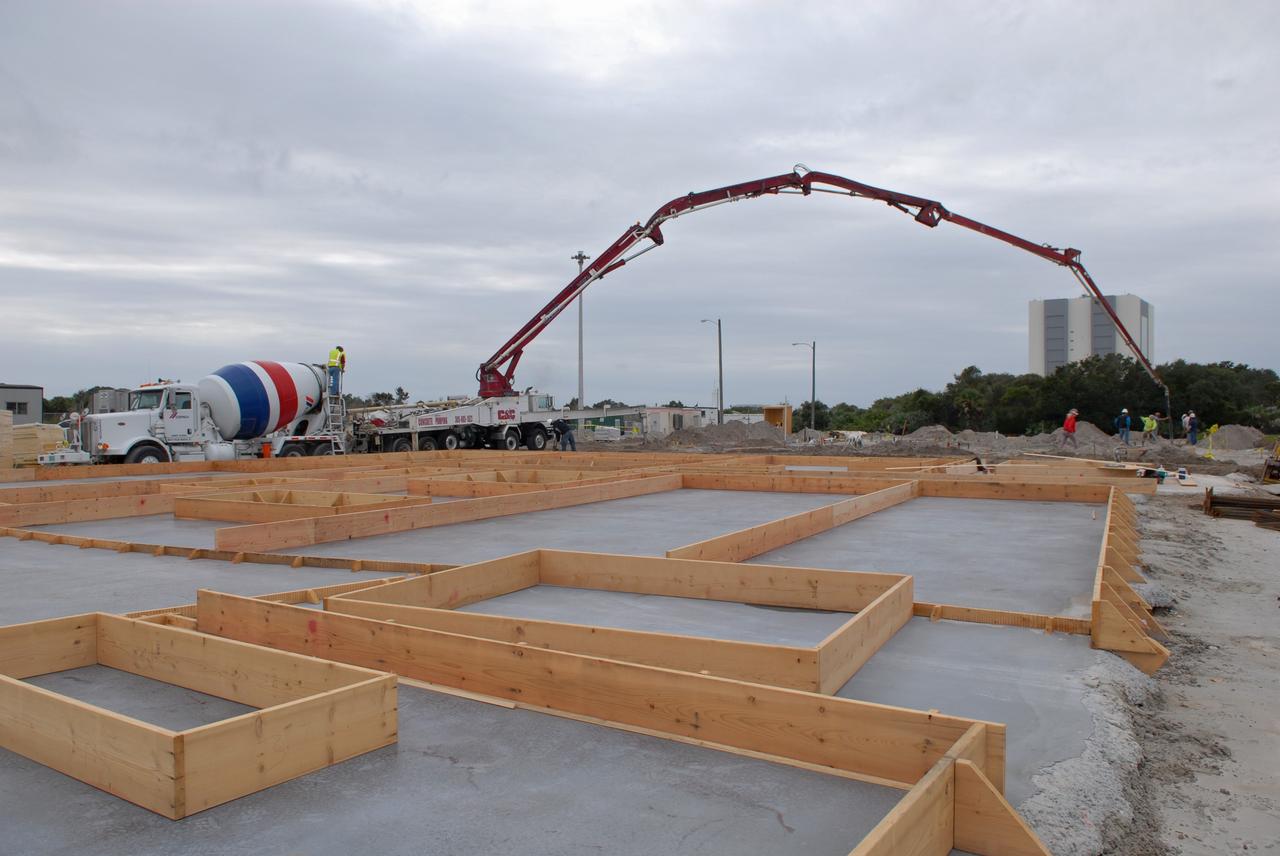 CAPE CANAVERAL, Fla. - In Launch Complex 39 at NASA's Kennedy Space Center in Florida, the walls for the Propellants North Administrative and Maintenance Facility get a layer of high-density foam insulation.    A tilt-up construction method is being used to erect a THERMOMASS concrete wall insulation system for the facility's walls.  In this approach, the exterior layer of concrete for the wall panels is poured and leveled on the building's footprint. Then, prefabricated, predrilled insulation sheets are arranged on top of the unhardened concrete, and connectors, designed to hold the sandwiched layers of concrete and insulation secure, are inserted through the predrilled holes. Next, the structural wythe is poured.  Once cured, these panels are lifted upright to form the building's envelope.  The facility will have a two-story administrative building to house managers, mechanics and technicians who fuel spacecraft at Kennedy adjacent to an 1,800-square-foot single-story shop to store cryogenic fuel transfer equipment.  The new facility will feature high-efficiency roofs and walls, “Cool Dry Quiet” air conditioning with energy recovery technology, efficient lighting, and other sustainable features. The facility is striving to qualify for the U.S. Green Building Council’s Leadership in Energy and Environmental Design, or LEED, Platinum certification. If successful, Propellants North will be the first Kennedy facility to achieve this highest of LEED ratings after it is completed in the summer of 2010.  The facility was designed for NASA by Jones Edmunds and Associates.  Photo credit: NASA/Jim Grossmann