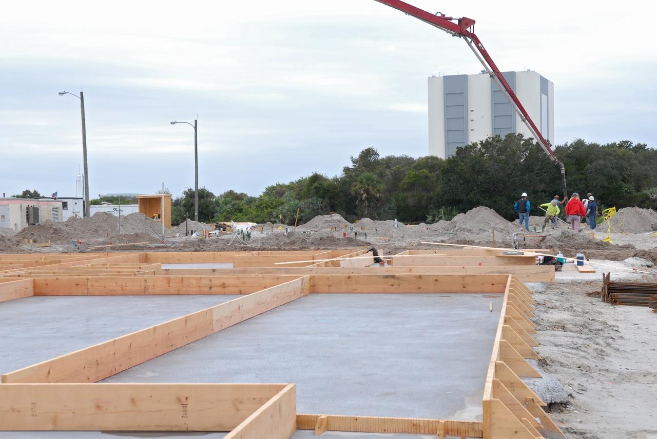CAPE CANAVERAL, Fla. - In Launch Complex 39 at NASA's Kennedy Space Center in Florida, high-density foam insulation between the concrete layers of the Propellants North Administrative and Maintenance Facility's walls will prevent any transfer of radiant heat between the exterior and interior of the building.    A tilt-up construction method is being used to erect a THERMOMASS concrete wall insulation system for the facility's walls.  In this approach, the exterior layer of concrete for the wall panels is poured and leveled on the building's footprint. Then, prefabricated, predrilled insulation sheets are arranged on top of the unhardened concrete, and connectors, designed to hold the sandwiched layers of concrete and insulation secure, are inserted through the predrilled holes. Next, the structural wythe is poured.  Once cured, these panels are lifted upright to form the building's envelope.  The facility will have a two-story administrative building to house managers, mechanics and technicians who fuel spacecraft at Kennedy adjacent to an 1,800-square-foot single-story shop to store cryogenic fuel transfer equipment.  The new facility will feature high-efficiency roofs and walls, “Cool Dry Quiet” air conditioning with energy recovery technology, efficient lighting, and other sustainable features. The facility is striving to qualify for the U.S. Green Building Council’s Leadership in Energy and Environmental Design, or LEED, Platinum certification. If successful, Propellants North will be the first Kennedy facility to achieve this highest of LEED ratings after it is completed in the summer of 2010.  The facility was designed for NASA by Jones Edmunds and Associates.  Photo credit: NASA/Jim Grossmann