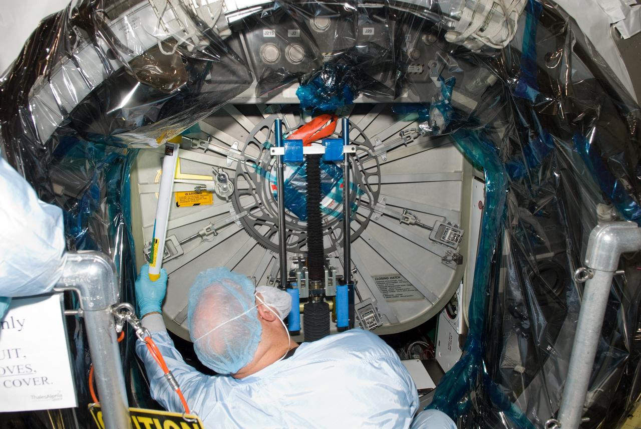 CAPE CANAVERAL, Fla. – In the Space Station Processing Facility at NASA's Kennedy Space Center in Florida, a worker dressed in clean room attire, known as a bunny suit, secures the hatch on the International Space Station's Node 3, named Tranquility.    Hatch closure follows the completion of preparations for the node's transport to the pad and is a significant milestone in launch processing activities. The primary payload for the STS-130 mission, Tranquility is a pressurized module that will provide room for many of the space station's life support systems. Attached to one end of Tranquility is a cupola, a unique work area with six windows on its sides and one on top.  The cupola resembles a circular bay window and will provide a vastly improved view of the station's exterior. The multi-directional view will allow the crew to monitor spacewalks and docking operations, as well as provide a spectacular view of Earth and other celestial objects. The module was built in Turin, Italy, by Thales Alenia Space for the European Space Agency.  Space shuttle Endeavour's STS-130 mission is targeted for launch in early February 2010. For information on the STS-130 mission and crew, visit http://www.nasa.gov/mission_pages/shuttle/shuttlemissions/sts130/index.html.  Photo credit: NASA/Jim Grossmann