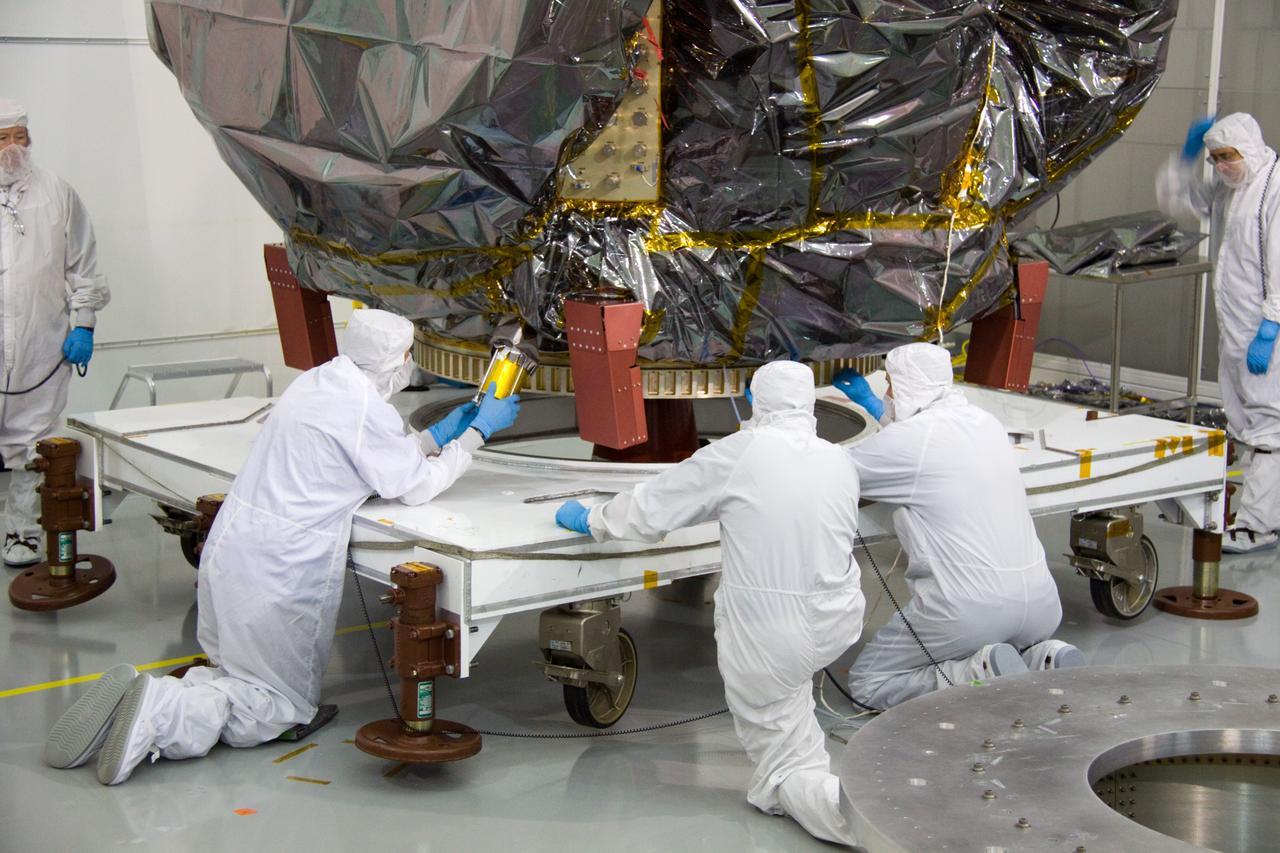 CAPE CANAVERAL, Fla. – At the Astrotech Space Operations facility in Titusville, Fla., NASA Goddard Space Flight Center technician Carl Clause, second from left, installs an aft omni coupler on the bagged Solar Dynamics Observatory, or SDO.    SDO is the first space weather research network mission in NASA's Living With a Star Program. The spacecraft's long-term measurements will give solar scientists in-depth information about changes in the sun's magnetic field and insight into how they affect Earth. Liftoff on an Atlas V rocket is scheduled for Feb. 3, 2010. For information on SDO, visit http://www.nasa.gov/sdo.  Photo credit: NASA/Troy Cryder