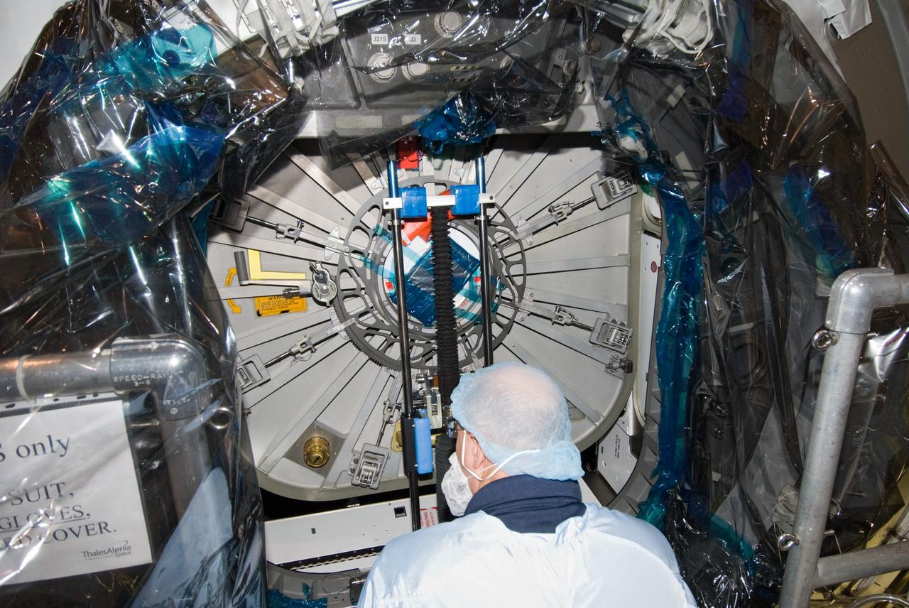 CAPE CANAVERAL, Fla. – In the Space Station Processing Facility at NASA's Kennedy Space Center in Florida, a payload technician dressed in clean room attire, known as a bunny suit, secures the hatch on the International Space Station's Node 3, named Tranquility.    Hatch closure follows the completion of preparations for the node's transport to the pad and is a significant milestone in launch processing activities. The primary payload for the STS-130 mission, Tranquility is a pressurized module that will provide room for many of the space station's life support systems. Attached to one end of Tranquility is a cupola, a unique work area with six windows on its sides and one on top.  The cupola resembles a circular bay window and will provide a vastly improved view of the station's exterior. The multi-directional view will allow the crew to monitor spacewalks and docking operations, as well as provide a spectacular view of Earth and other celestial objects. The module was built in Turin, Italy, by Thales Alenia Space for the European Space Agency.  Space shuttle Endeavour's STS-130 mission is targeted for launch in early February 2010. For information on the STS-130 mission and crew, visit http://www.nasa.gov/mission_pages/shuttle/shuttlemissions/sts130/index.html.  Photo credit: NASA/Amanda Diller