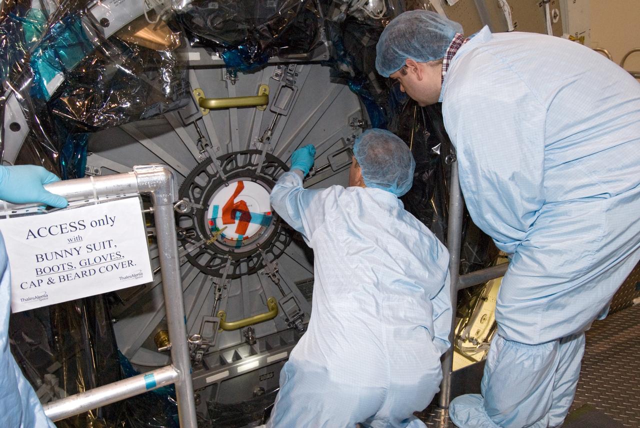 CAPE CANAVERAL, Fla. – In the Space Station Processing Facility at NASA's Kennedy Space Center in Florida, payload technicians dressed in clean room attire, known as bunny suits, secure the hatch on the International Space Station's Node 3, named Tranquility.    Hatch closure follows the completion of preparations for the node's transport to the pad and is a significant milestone in launch processing activities. The primary payload for the STS-130 mission, Tranquility is a pressurized module that will provide room for many of the space station's life support systems. Attached to one end of Tranquility is a cupola, a unique work area with six windows on its sides and one on top.  The cupola resembles a circular bay window and will provide a vastly improved view of the station's exterior. The multi-directional view will allow the crew to monitor spacewalks and docking operations, as well as provide a spectacular view of Earth and other celestial objects. The module was built in Turin, Italy, by Thales Alenia Space for the European Space Agency.  Space shuttle Endeavour's STS-130 mission is targeted for launch in early February 2010. For information on the STS-130 mission and crew, visit http://www.nasa.gov/mission_pages/shuttle/shuttlemissions/sts130/index.html.  Photo credit: NASA/Amanda Diller