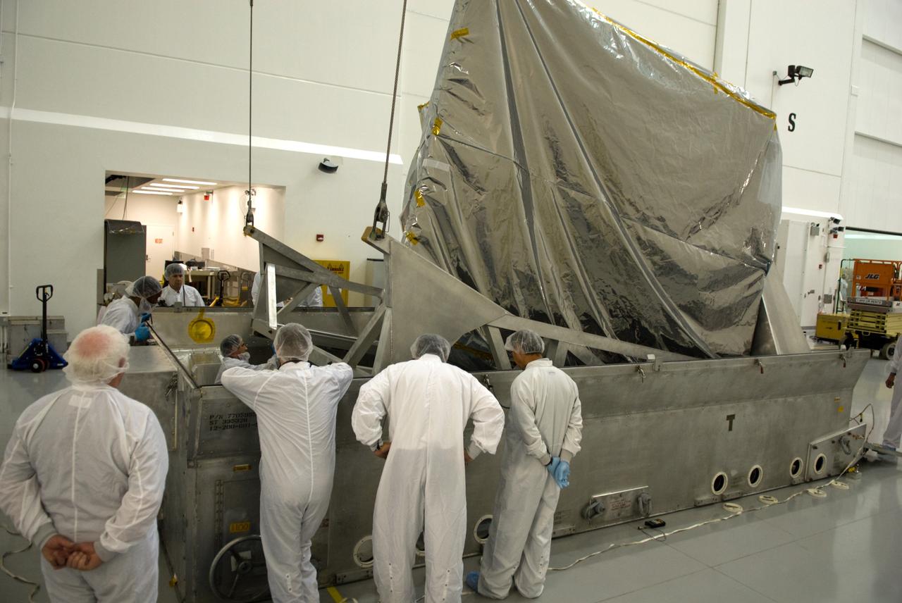CAPE CANAVERAL, Fla. – At the Astrotech Space Operations facility in Titusville, Fla., workers prepare to lift NASA's newly arrived GOES-P meteorological satellite from its transportation case.    GOES-P, the latest Geostationary Operational Environmental Satellite, was developed by NASA for the National Oceanic and Atmospheric Administration, or NOAA.  GOES-P is designed to watch for storm development and observed current weather conditions on Earth.  Launch of GOES-P is targeted for no earlier than Feb. 25, 2010, from Launch Complex 37 aboard a United Launch Alliance Delta IV rocket.  For information on GOES-P, visit http://goespoes.gsfc.nasa.gov/goes/spacecraft/n_p_spacecraft.html. Photo credit: NASA/Glenn Benson