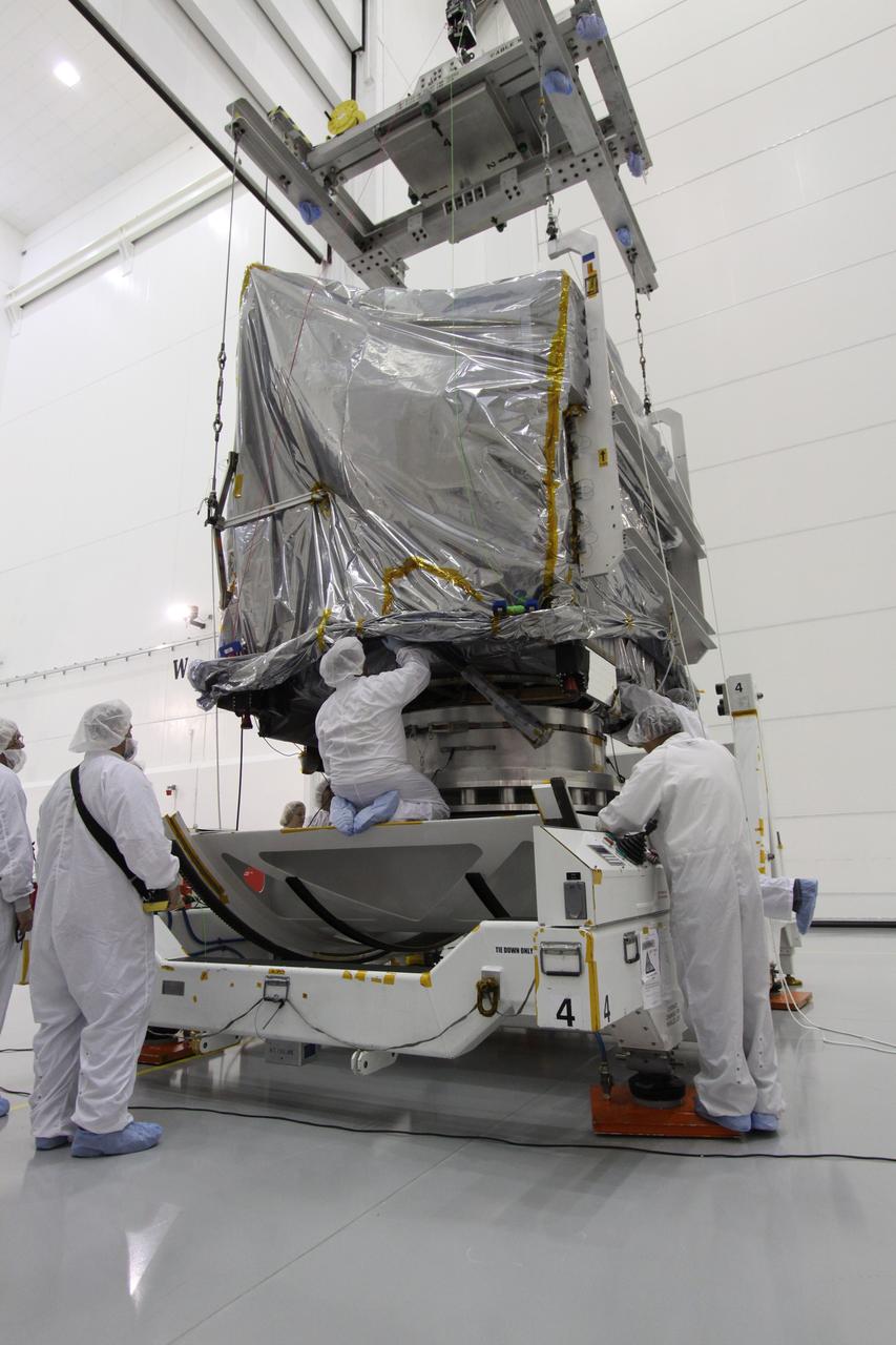 CAPE CANAVERAL, Fla. – At the Astrotech Space Operations facility in Titusville, Fla., workers secure NASA's GOES-P meteorological satellite, covered in a protective bag, on a Ransome table on which it will be rotated for further testing. GOES-P, the latest Geostationary Operational Environmental Satellite, was developed by NASA for the National Oceanic and Atmospheric Administration, or NOAA. GOES-P is designed to watch for storm development and observed current weather conditions on Earth. Launch of GOES-P is targeted for no earlier than Feb. 25, 2010, from Launch Complex 37 aboard a United Launch Alliance Delta IV rocket. For information on GOES-P, visit http://goespoes.gsfc.nasa.gov/goes/spacecraft/n_p_spacecraft.html. Photo credit: NASA/Jack Pfaller