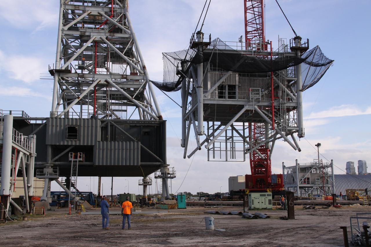 CAPE CANAVERAL, Fla. – At NASA's Kennedy Space Center in Florida, the seventh tower segment of a new mobile launcher, or ML, being constructed to support the Constellation Program, seems to hover above the ground as it is lifted by crane toward the launcher's growing tower. When completed, the tower will be approximately 345 feet tall and have multiple platforms for personnel access. The construction is under way at the mobile launcher park site area north of Kennedy's Vehicle Assembly Building. The launcher will provide a base to launch the Ares I rocket, designed to transport the Orion crew exploration vehicle, its crew and cargo to low Earth orbit. Its base is being made lighter than space shuttle mobile launcher platforms so the crawler-transporter can pick up the heavier load of the tower and taller rocket. For information on the Ares I, visit http://www.nasa.gov/ares. Photo credit: NASA/Jack Pfaller