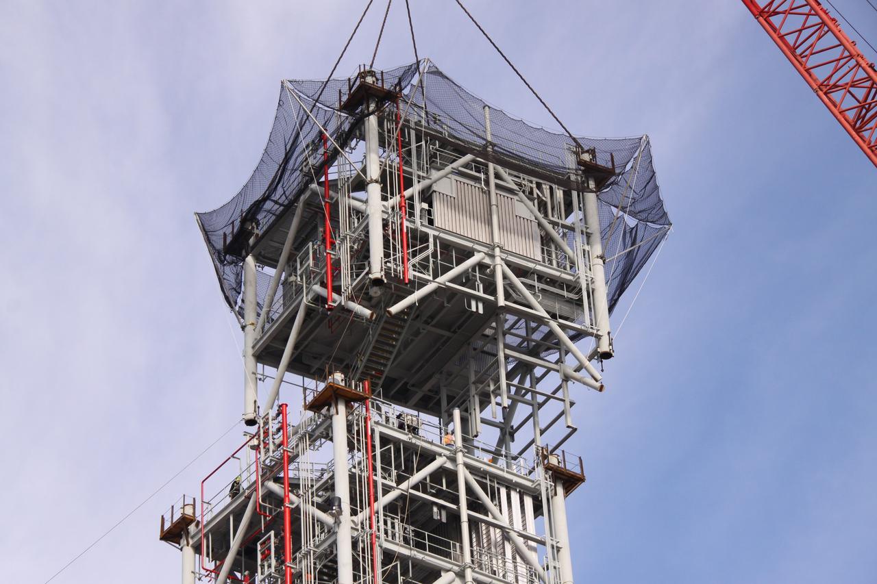 CAPE CANAVERAL, Fla. – At NASA's Kennedy Space Center in Florida, a crane gently lowers a seventh tower segment onto the six segments previously secured to a new mobile launcher, or ML, being constructed to support the Constellation Program. When completed, the tower will be approximately 345 feet tall and have multiple platforms for personnel access. The construction is under way at the mobile launcher park site area north of Kennedy's Vehicle Assembly Building. The launcher will provide a base to launch the Ares I rocket, designed to transport the Orion crew exploration vehicle, its crew and cargo to low Earth orbit. Its base is being made lighter than space shuttle mobile launcher platforms so the crawler-transporter can pick up the heavier load of the tower and taller rocket. For information on the Ares I, visit http://www.nasa.gov/ares. Photo credit: NASA/Jack Pfaller