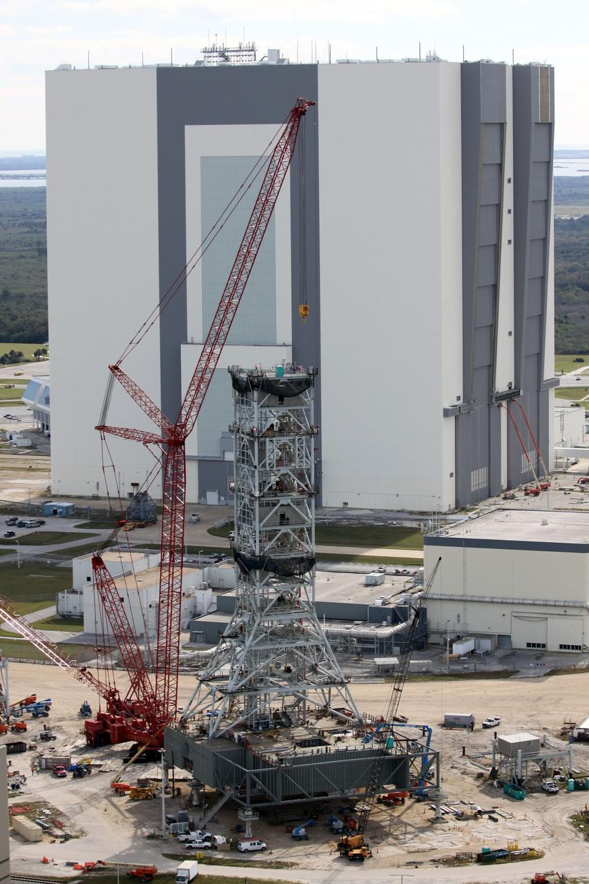 CAPE CANAVERAL, Fla. – At NASA's Kennedy Space Center in Florida, this aerial view of the mobile launcher park site area north of the 525-foot-tall Vehicle Assembly Building, in the background, shows a new mobile launcher, or ML, under construction to support the Constellation Program.    When completed, the tower will be approximately 345 feet tall and have multiple platforms for personnel access. Its base is being made lighter than space shuttle mobile launcher platforms so the crawler-transporter can pick up the heavier load of the tower and a taller rocket.  For information on the Constellation Program, visit http://www.nasa.gov/constellation. Photo credit: NASA/Cory Huston