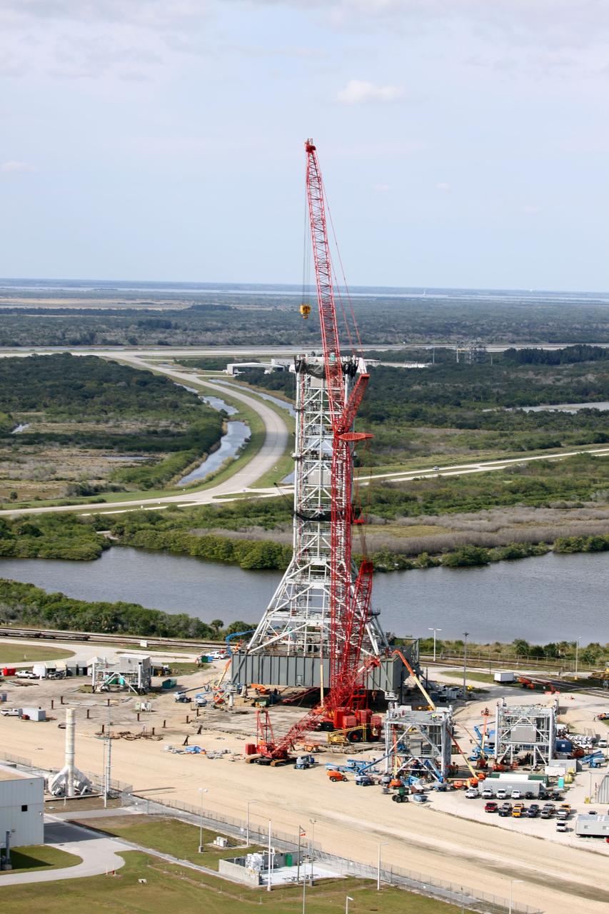 CAPE CANAVERAL, Fla. - At NASA's Kennedy Space Center in Florida, this aerial view of the mobile launcher park site area north of the 525-foot-tall Vehicle Assembly Building shows a new mobile launcher, or ML, for the Constellation Program under construction.  In the background are the Shuttle Landing Facility runway, the towway and the mate-demate device.    When completed, the tower will be approximately 345 feet tall and have multiple platforms for personnel access. Its base is being made lighter than space shuttle mobile launcher platforms so the crawler-transporter can pick up the heavier load of the tower and a taller rocket.  For information on the Constellation Program, visit http://www.nasa.gov/constellation. Photo credit: NASA/Cory Huston
