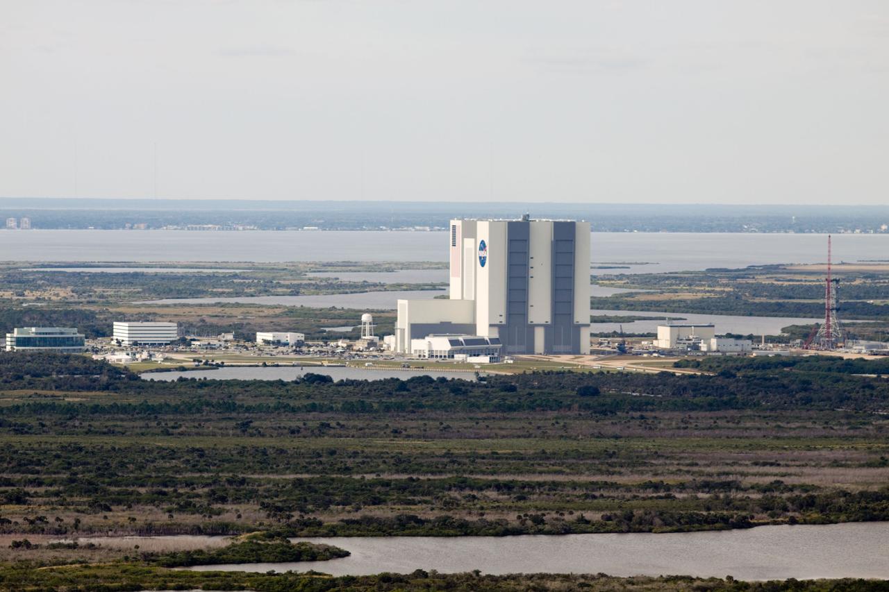 CAPE CANAVERAL, Fla. – At NASA's Kennedy Space Center in Florida, this aerial view of Launch Complex 39 shows a new mobile launcher, or ML, for the Constellation Program, at far right, being constructed in the mobile launcher park site area north of the 525-foot-tall Vehicle Assembly Building.  In the background is the Indian River.    When completed, the tower will be approximately 345 feet tall and have multiple platforms for personnel access. Its base is being made lighter than space shuttle mobile launcher platforms so the crawler-transporter can pick up the heavier load of the tower and a taller rocket.  For information on the Constellation Program, visit http://www.nasa.gov/constellation. Photo credit: NASA/Cory Huston