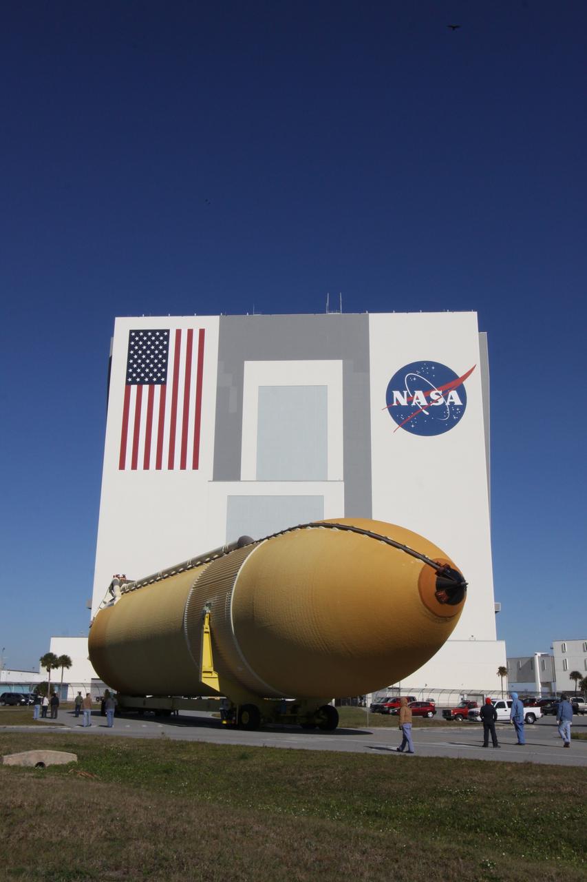 CAPE CANAVERAL, Fla. – At NASA's Kennedy Space Center in Florida, workers accompany External Tank-135 as it is transported to the 525-foot-tall Vehicle Assembly Building, looming in the background. The tank arrived in Florida on Dec. 26 aboard the Pegasus barge, towed by a solid rocket booster retrieval ship from NASA's Michoud Assembly Facility near New Orleans. ET-135 will be used to launch space shuttle Discovery on the STS-131 mission to the International Space Station. Launch is targeted for March 18. For information on the components of the space shuttle and the STS-131 mission, visit http://www.nasa.gov/mission_pages/shuttle/shuttlemissions/sts131/index.html. Photo credit: NASA/Jack Pfaller