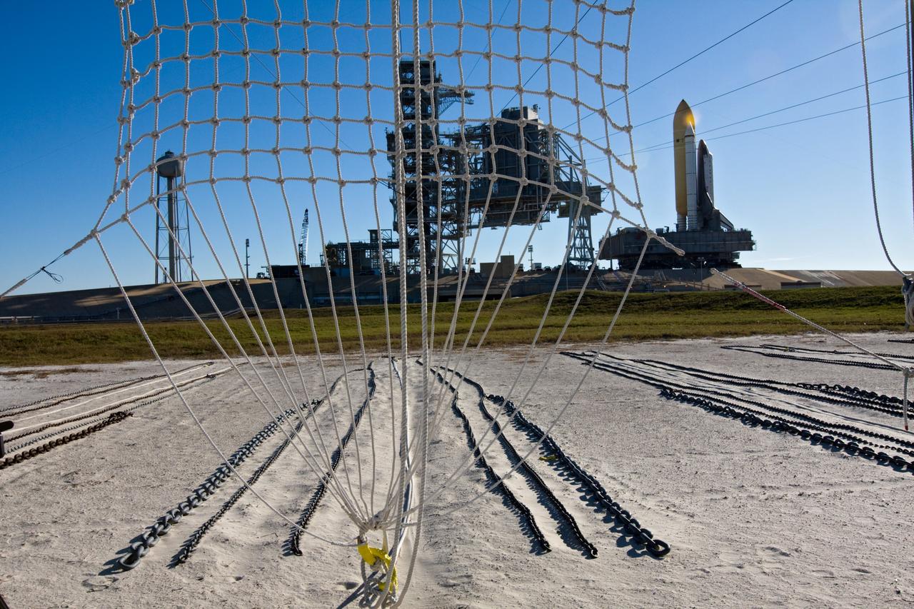 CAPE CANAVERAL, Fla. – At NASA's Kennedy Space Center in Florida, space shuttle Endeavour approaches Launch Pad 39A as seen through a catch net for a slidewire basket, part of the emergency egress system at the pad.  The system includes seven baskets suspended from seven slidewires that extend from the fixed service structure to a landing zone 1,200 feet west of the pad.  Endeavour's first motion on its 3.4-mile trek from the Vehicle Assembly Building, known as rollout, was at 4:13 a.m. EST Jan. 6.  Endeavour was secure or "hard down" on the pad at 10:37 a.m.    Rollout is a significant milestone in launch processing activities. The primary payload for the STS-130 mission is the International Space Station's Node 3, Tranquility, a pressurized module that will provide room for many of the station's life support systems. Attached to one end of Tranquility is a cupola, a unique work area with six windows on its sides and one on top.  The cupola resembles a circular bay window and will provide a vastly improved view of the station's exterior. The multi-directional view will allow the crew to monitor spacewalks and docking operations, as well as provide a spectacular view of Earth and other celestial objects. The module was built in Turin, Italy, by Thales Alenia Space for the European Space Agency.  Endeavour's STS-130 launch is targeted for 4:39 a.m. EST Feb. 7. For information on the STS-130 mission and crew, visit http://www.nasa.gov/mission_pages/shuttle/shuttlemissions/sts130/index.html.  Photo credit: NASA/Amanda Diller