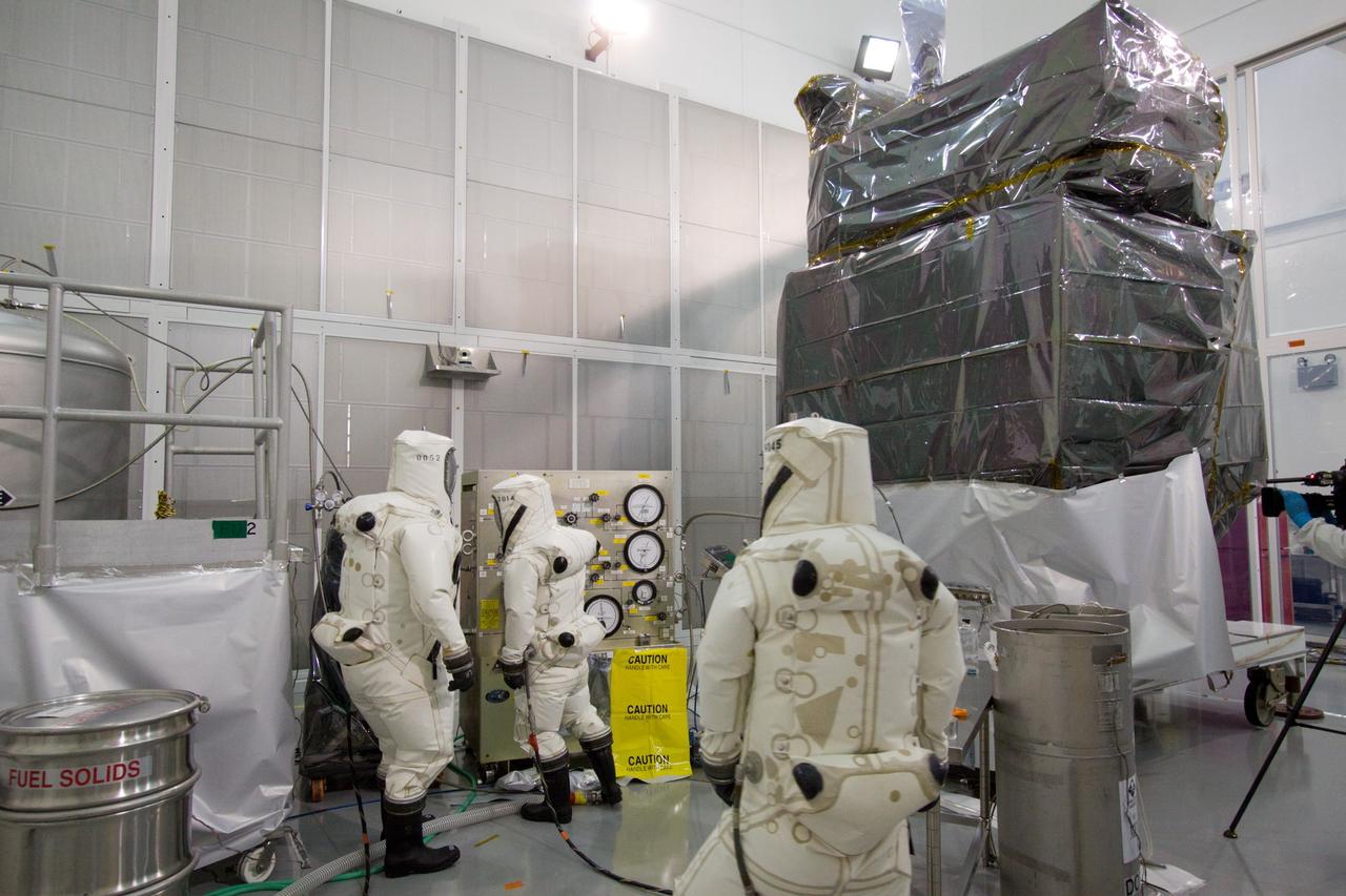 CAPE CANAVERAL, Fla. – At the Astrotech Space Operations facility in Titusville, Fla., Boeing spacecraft fueling technicians from Kennedy Space Center prepare to sample the monomethylhydrazine propellant that will be loaded aboard the Solar Dynamics Observatory, or SDO, which is protectively covered.    The hydrazine fuel is being sampled for purity before it is loaded aboard the spacecraft.  The technicians are dressed in self-contained atmospheric protective ensemble suits, or SCAPE suits, as a safety precaution in the unlikely event that any of the highly toxic chemical should escape from the storage tank. The nitrogen tetroxide oxidizer was loaded earlier in the week which is customarily followed by loading of the fuel.  Propellant loading is one of the final processing milestones before the spacecraft is encapsulated in its fairing for launch.  SDO is the first mission in NASA's Living With a Star Program and is designed to study the causes of solar variability and its impacts on Earth. The spacecraft's long-term measurements will give solar scientists in-depth information to help characterize the interior of the Sun, the Sun's magnetic field, the hot plasma of the solar corona, and the density of radiation that creates the ionosphere of the planets. The information will be used to create better forecasts of space weather needed to protect the aircraft, satellites and astronauts living and working in space. Liftoff aboard an Atlas V rocket is targeted for Feb. 9 from Launch Complex 41 on Cape Canaveral Air Force Station. For information on SDO, visit http://www.nasa.gov/sdo.  Photo credit: NASA/Jack Pfaller