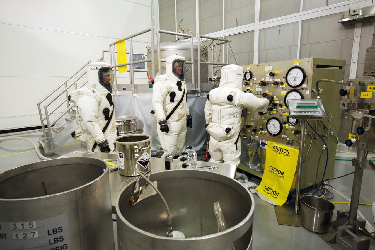 CAPE CANAVERAL, Fla. – At the Astrotech Space Operations facility in Titusville, Fla., Boeing spacecraft fueling technicians from Kennedy Space Center prepare the equipment necessary to sample the monomethylhydrazine propellant that will be loaded aboard the Solar Dynamics Observatory, or SDO.    The hydrazine fuel is being sampled for purity before it is loaded aboard the spacecraft.  The technicians are dressed in self-contained atmospheric protective ensemble suits, or SCAPE suits, as a safety precaution in the unlikely event that any of the highly toxic chemical should escape from the storage tank. The nitrogen tetroxide oxidizer was loaded earlier in the week which is customarily followed by loading of the fuel.  Propellant loading is one of the final processing milestones before the spacecraft is encapsulated in its fairing for launch.  SDO is the first mission in NASA's Living With a Star Program and is designed to study the causes of solar variability and its impacts on Earth. The spacecraft's long-term measurements will give solar scientists in-depth information to help characterize the interior of the Sun, the Sun's magnetic field, the hot plasma of the solar corona, and the density of radiation that creates the ionosphere of the planets. The information will be used to create better forecasts of space weather needed to protect the aircraft, satellites and astronauts living and working in space. Liftoff aboard an Atlas V rocket is targeted for Feb. 9 from Launch Complex 41 on Cape Canaveral Air Force Station. For information on SDO, visit http://www.nasa.gov/sdo.  Photo credit: NASA/Jack Pfaller
