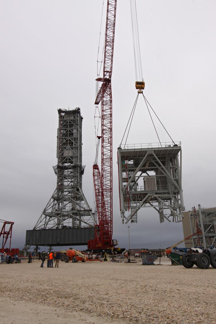 CAPE CANAVERAL, Fla. – At NASA's Kennedy Space Center in Florida, the eighth tower segment of a new mobile launcher, or ML, being constructed to support the Constellation Program, begins its ascent to the top of the growing tower. When completed, the tower will be approximately 345 feet tall and have multiple platforms for personnel access. The construction is under way at the mobile launcher park site area north of Kennedy's Vehicle Assembly Building. The launcher will provide a base to launch the Ares I rocket, designed to transport the Orion crew exploration vehicle, its crew and cargo to low Earth orbit. Its base is being made lighter than space shuttle mobile launcher platforms so the crawler-transporter can pick up the heavier load of the tower and taller rocket. For information on the Ares I, visit http://www.nasa.gov/ares. Photo credit: NASA/Jack Pfaller