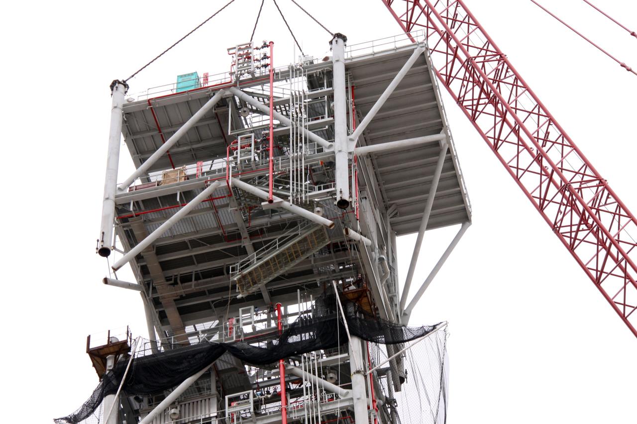CAPE CANAVERAL, Fla. – At NASA's Kennedy Space Center in Florida, a crane slowly eases the eighth tower segment of a new mobile launcher, or ML, being constructed to support the Constellation Program, into position over the seven segments already secured to the launcher's surface.    When completed, the tower will be approximately 345 feet tall and have multiple platforms for personnel access. The construction is under way at the mobile launcher park site area north of Kennedy's Vehicle Assembly Building. The launcher will provide a base to launch the Ares I rocket, designed to transport the Orion crew exploration vehicle, its crew and cargo to low Earth orbit. Its base is being made lighter than space shuttle mobile launcher platforms so the crawler-transporter can pick up the heavier load of the tower and taller rocket.  For information on the Ares I, visit http://www.nasa.gov/ares. Photo credit: NASA/Jack Pfaller
