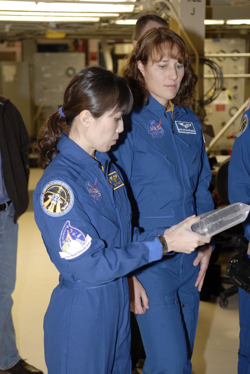 CAPE CANAVERAL, Fla. - In Orbiter Processing Facility 3 at NASA's Kennedy Space Center in Florida, members of space shuttle Discovery's STS-131 crew participate in training activities during the Crew Equipment Interface Test, or CEIT, for their mission. Here, Mission Specialists Naoko Yamazaki of the Japan Aerospace Exploration Agency and Dorothy Metcalf-Lindenburger examine a thermal protection system tile. The CEIT provides the crew with hands-on training and observation of shuttle and flight hardware. The seven-member crew will deliver the multi-purpose logistics module Leonardo, filled with resupply stowage platforms and racks to be transferred to locations around the International Space Station. Three spacewalks will include work to attach a spare ammonia tank assembly to the station's exterior and return a European experiment from outside the station's Columbus module. Discovery's launch is targeted for March 18. For information on the STS-131 mission and crew, visit http://www.nasa.gov/mission_pages/shuttle/shuttlemissions/sts131/index.html. Photo credit: NASA/Kim Shiflett