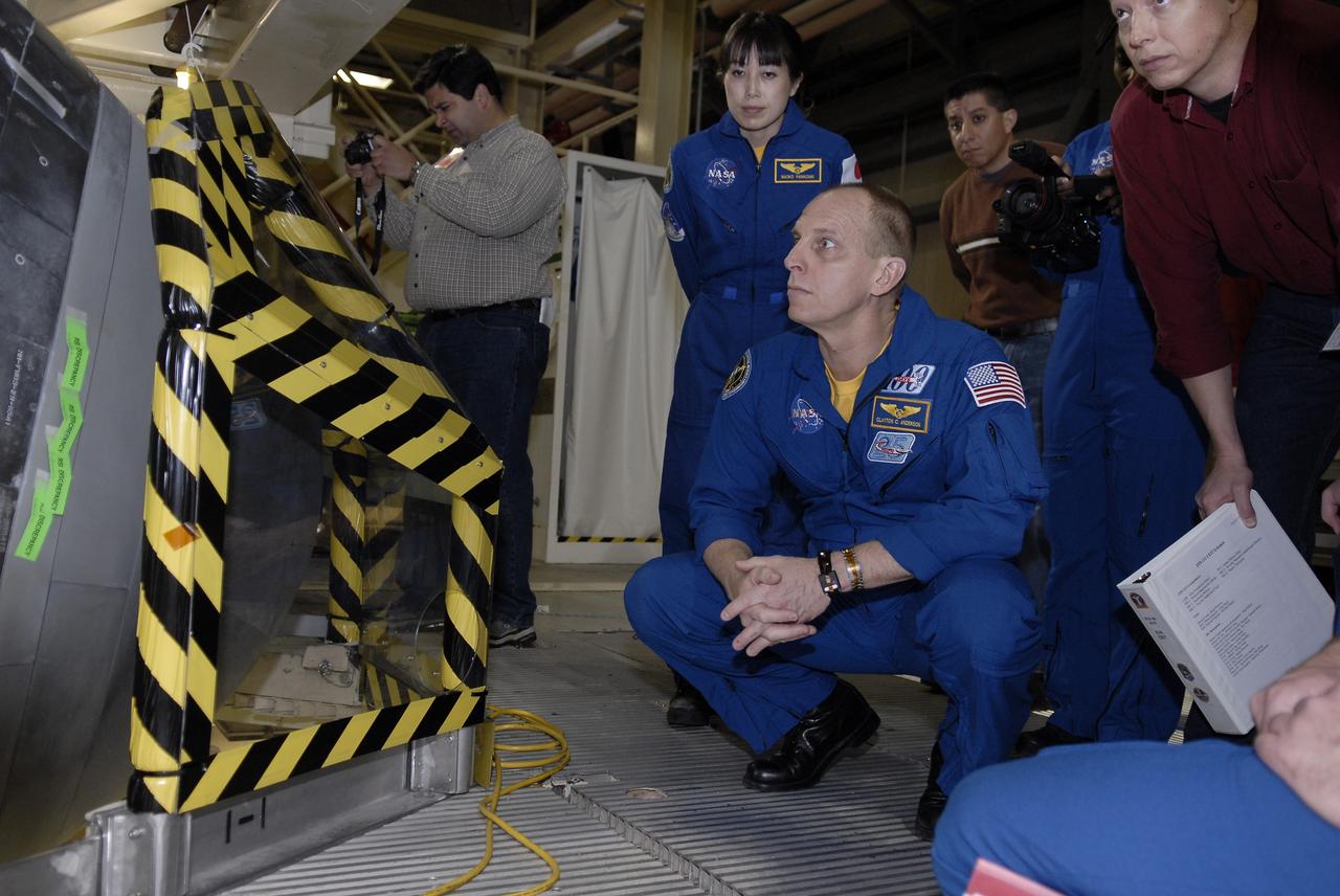 CAPE CANAVERAL, Fla. - In Orbiter Processing Facility 3 at NASA's Kennedy Space Center in Florida, members of space shuttle Discovery's STS-131 crew participate in training activities during the Crew Equipment Interface Test, or CEIT, for their mission.  Here, Mission Specialists Naoko Yamazaki of the Japan Aerospace Exploration Agency and Clay Anderson, kneeling, get a close look at the exterior of a window on Discovery's crew module.    The CEIT provides the crew with hands-on training and observation of shuttle and flight hardware. The seven-member crew will deliver the multi-purpose logistics module Leonardo, filled with resupply stowage platforms and racks to be transferred to locations around the International Space Station.  Three spacewalks will include work to attach a spare ammonia tank assembly to the station's exterior and return a European experiment from outside the station's Columbus module.  Discovery's launch is targeted for March 18.  For information on the STS-131 mission and crew, visit http://www.nasa.gov/mission_pages/shuttle/shuttlemissions/sts131/index.html.  Photo credit: NASA/Kim Shiflett