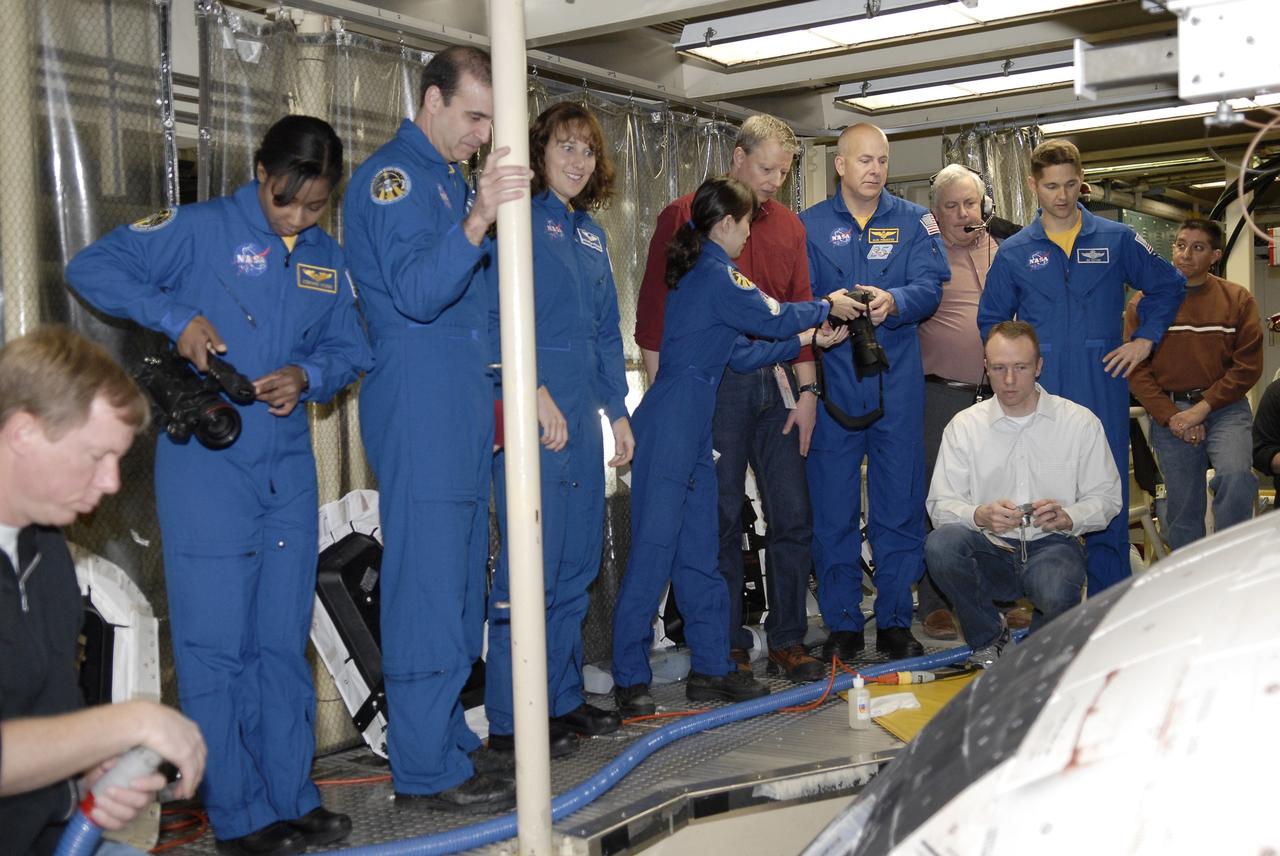 CAPE CANAVERAL, Fla. - In Orbiter Processing Facility 3 at NASA's Kennedy Space Center in Florida, members of space shuttle Discovery's STS-131 crew participate in training activities during the Crew Equipment Interface Test, or CEIT, for their mission.  From left in the blue flight suits, Mission Specialists Stephanie Wilson, Rick Mastracchio, Dorothy Metcalf-Lindenburger, and Naoko Yamazaki of the Japan Aerospace Exploration Agency; Commander Alan Poindexter; and Pilot James P. Dutton Jr. get a close look at the exterior of the windows on Discovery's crew module.    The CEIT provides the crew with hands-on training and observation of shuttle and flight hardware. The seven-member crew will deliver the multi-purpose logistics module Leonardo, filled with resupply stowage platforms and racks to be transferred to locations around the International Space Station.  Three spacewalks will include work to attach a spare ammonia tank assembly to the station's exterior and return a European experiment from outside the station's Columbus module.  Discovery's launch is targeted for March 18.  For information on the STS-131 mission and crew, visit http://www.nasa.gov/mission_pages/shuttle/shuttlemissions/sts131/index.html.  Photo credit: NASA/Kim Shiflett