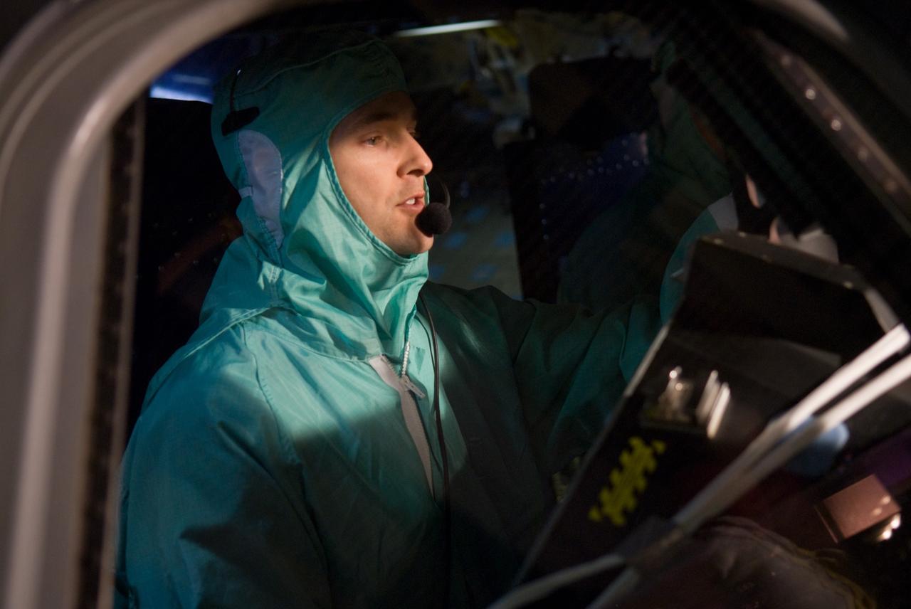 CAPE CANAVERAL, Fla. - In Orbiter Processing Facility 3 at NASA's Kennedy Space Center in Florida, members of space shuttle Discovery's STS-131 crew participate in training activities during the Crew Equipment Interface Test, or CEIT, for their mission.  Here, Pilot James P. Dutton Jr. experiences the feel of the cockpit from inside the crew module.    The CEIT provides the crew with hands-on training and observation of shuttle and flight hardware. The seven-member crew will deliver the multi-purpose logistics module Leonardo, filled with resupply stowage platforms and racks to be transferred to locations around the International Space Station.  Three spacewalks will include work to attach a spare ammonia tank assembly to the station's exterior and return a European experiment from outside the station's Columbus module.  Discovery's launch is targeted for March 18.  For information on the STS-131 mission and crew, visit http://www.nasa.gov/mission_pages/shuttle/shuttlemissions/sts131/index.html.  Photo credit: NASA/Kim Shiflett