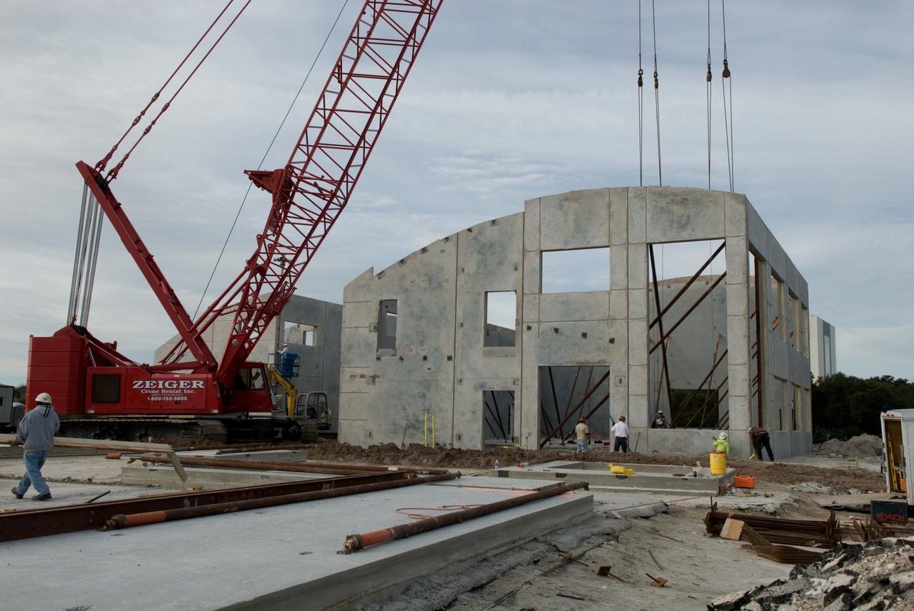 CAPE CANAVERAL, Fla. - In Launch Complex 39 at NASA's Kennedy Space Center in Florida, all of the exterior walls of the Propellants North Administrative and Maintenance Facility have been lifted into place.    Concrete layers on either side of high-density foam insulation in the facility's walls will prevent any transfer of radiant heat between the exterior and interior of the buildings.  A tilt-up construction method is being used to erect a THERMOMASS concrete wall insulation system for the facility's walls.  In this approach, the exterior layer of concrete for the wall panels is poured and leveled on the building's footprint. Then, prefabricated, predrilled insulation sheets are arranged on top of the unhardened concrete, and connectors, designed to hold the sandwiched layers of concrete and insulation secure, are inserted through the predrilled holes. Next, the structural wythe is poured.  Once cured, these panels are lifted upright to form the building's envelope.  The facility will have a two-story administrative building to house managers, mechanics and technicians who fuel spacecraft at Kennedy adjacent to an 1,800-square-foot single-story shop to store cryogenic fuel transfer equipment.  The new facility will feature high-efficiency roofs and walls, “Cool Dry Quiet” air conditioning with energy recovery technology, efficient lighting, and other sustainable features. The facility is striving to qualify for the U.S. Green Building Council’s Leadership in Energy and Environmental Design, or LEED, Platinum certification. If successful, Propellants North will be the first Kennedy facility to achieve this highest of LEED ratings after it is completed in the summer of 2010.  The facility was designed for NASA by Jones Edmunds and Associates.  Photo credit: NASA/Jim Grossmann