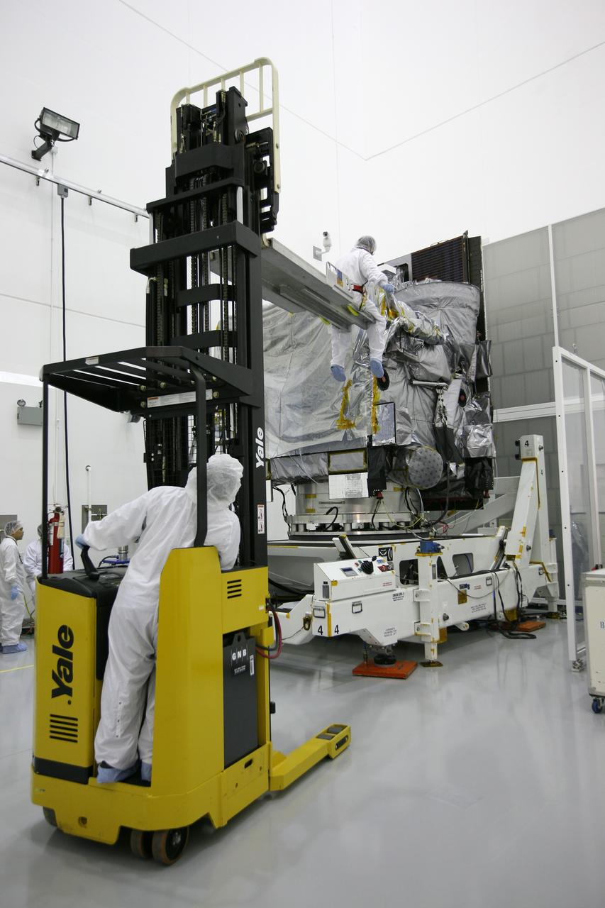 CAPE CANAVERAL, Fla. – At the Astrotech Space Operations facility in Titusville, Fla., a spacecraft technician gets a lift to the top of NASA's GOES-P meteorological satellite to begin the unbagging process, the removal of its protective wrapping. GOES-P, the latest Geostationary Operational Environmental Satellite, was developed by NASA for the National Oceanic and Atmospheric Administration, or NOAA. GOES-P is designed to watch for storm development and observed current weather conditions on Earth. Launch of GOES-P is targeted for no earlier than March 1 from Launch Complex 37 aboard a United Launch Alliance Delta IV rocket. For information on GOES-P, visit http://goespoes.gsfc.nasa.gov/goes/spacecraft/n_p_spacecraft.html. Photo credit: NASA/Amanda Diller