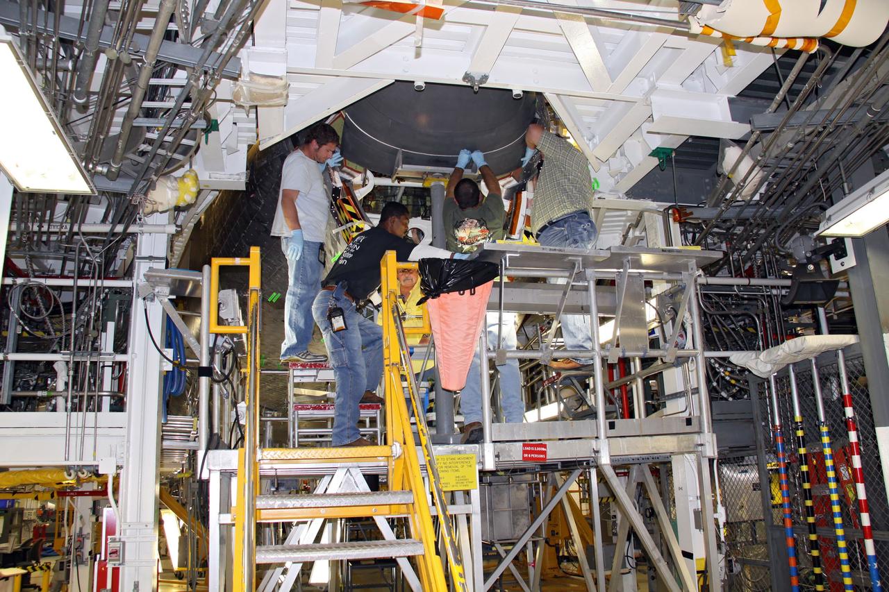 CAPE CANAVERAL, Fla. - In Orbiter Processing Facility 1 at NASA's Kennedy Space Center in Florida, a team of United Space Alliance technicians installs the chin panel on space shuttle Atlantis.    The chin panel is a semicircular-shaped section of reinforced carbon-carbon that fits under the shuttle's nose cap and is part of its thermal protection system.  Atlantis is next slated to deliver an Integrated Cargo Carrier and Russian-built Mini Research Module to the International Space Station on the STS-132 mission. The second in a series of new pressurized components for Russia, the module will be permanently attached to the Zarya module. Three spacewalks are planned to store spare components outside the station, including six spare batteries, a boom assembly for the Ku-band antenna and spares for the Canadian Dextre robotic arm extension. A radiator, airlock and European robotic arm for the Russian Multi-purpose Laboratory Module also are payloads on the flight.  Launch is targeted for May 14, 2010.    Photo credit: NASA/Ben Smegelsky