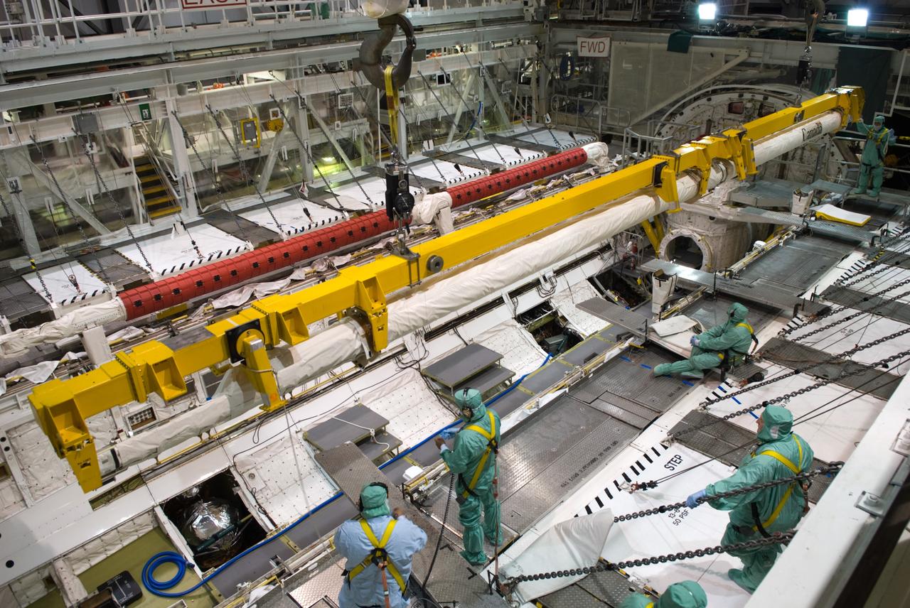 CAPE CANAVERAL, Fla. - In Orbiter Processing Facility 1 at NASA's Kennedy Space Center in Florida, a crane lowers the orbiter boom sensor system, or OBSS, into space shuttle Atlantis' payload bay where it will be installed. The OBSS' inspection boom assembly, or IBA, is removed from the arm every other processing flow for a detailed inspection. After five consecutive flights, all IBA internal components are submitted to a thorough electrical checkout in the Remote Manipulator System Lab. The 50-foot-long OBSS attaches to the end of the shuttle’s robotic arm and supports the cameras and laser systems used to inspect the shuttle’s thermal protection system while in space. Atlantis is next slated to deliver an Integrated Cargo Carrier and Russian-built Mini Research Module to the International Space Station on the STS-132 mission. Launch is targeted for May 14. Photo credit: NASA/Jim Grossmann