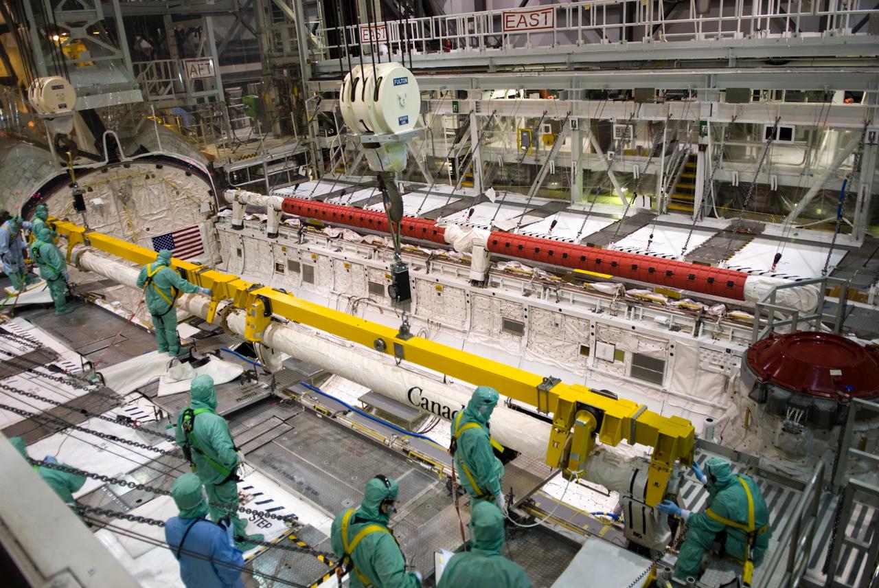 CAPE CANAVERAL, Fla. - In Orbiter Processing Facility 1 at NASA's Kennedy Space Center in Florida, technicians install the orbiter boom sensor system, or OBSS, in space shuttle Atlantis' payload bay across from the remote manipulator system arm. The OBSS' inspection boom assembly, or IBA, is removed from the arm every other processing flow for a detailed inspection. After five consecutive flights, all IBA internal components are submitted to a thorough electrical checkout in the Remote Manipulator System Lab. The 50-foot-long OBSS attaches to the end of the shuttle’s robotic arm and supports the cameras and laser systems used to inspect the shuttle’s thermal protection system while in space. Atlantis is next slated to deliver an Integrated Cargo Carrier and Russian-built Mini Research Module to the International Space Station on the STS-132 mission. Launch is targeted for May 14. Photo credit: NASA/Jim Grossmann