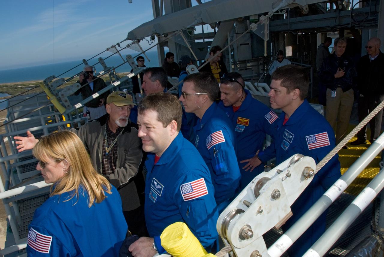 CAPE CANAVERAL, Fla. - On Launch Pad 39A at NASA's Kennedy Space Center in Florida, the members of space shuttle Endeavour's STS-130 crew get a close look at the pad's slidewire baskets, part of the emergency exit system at the pad. The system includes seven baskets suspended from seven slidewires that extend from the fixed service structure to a landing zone 1,200 feet west of the pad. The crew members of space shuttle Endeavour's upcoming mission are at Kennedy for training related to their launch dress rehearsal, the Terminal Countdown Demonstration Test. The primary payload on STS-130 is the International Space Station's Node 3, Tranquility, a pressurized module that will provide room for many of the station's life support systems. Attached to one end of Tranquility is a cupola, a unique work area with six windows on its sides and one on top. Endeavour's launch is targeted for Feb. 7. For information on the STS-130 mission and crew, visit http://www.nasa.gov/mission_pages/shuttle/shuttlemissions/sts130/index.html. Photo credit: NASA/Kim Shiflett