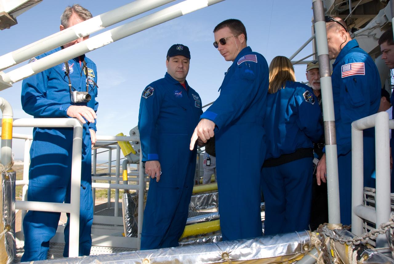 CAPE CANAVERAL, Fla. - On Launch Pad 39A at NASA's Kennedy Space Center in Florida, STS-130 Mission Specialist Nicholas Patrick, left, and Pilot Terry Virts become familiar with the configuration of a slidewire basket, part of the emergency exit system at the pad. The system includes seven baskets suspended from seven slidewires that extend from the fixed service structure to a landing zone 1,200 feet west of the pad. The crew members of space shuttle Endeavour's upcoming mission are at Kennedy for training related to their launch dress rehearsal, the Terminal Countdown Demonstration Test. The primary payload on STS-130 is the International Space Station's Node 3, Tranquility, a pressurized module that will provide room for many of the station's life support systems. Attached to one end of Tranquility is a cupola, a unique work area with six windows on its sides and one on top. Endeavour's launch is targeted for Feb. 7. For information on the STS-130 mission and crew, visit http://www.nasa.gov/mission_pages/shuttle/shuttlemissions/sts130/index.html. Photo credit: NASA/Kim Shiflett