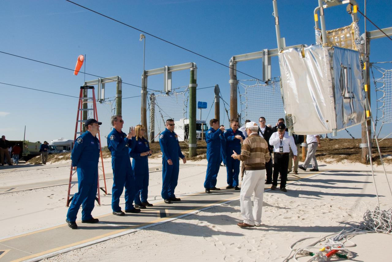 CAPE CANAVERAL, Fla. - On Launch Pad 39A at NASA's Kennedy Space Center in Florida, the members of space shuttle Endeavour's STS-130 crew continue their emergency exit training by the catch nets for the slidewire baskets at the base of the pad. The emergency exit system includes seven baskets suspended from seven slidewires that extend from the fixed service structure to a landing zone 1,200 feet west of the pad.  The astronauts are, from left, Mission Specialists Nicholas Patrick, Stephen Robinson and Kathryn Hire; Commander George Zamka; Mission Specialist Robert Behnken; and Pilot Terry Virts.    The crew members of space shuttle Endeavour's upcoming mission are at Kennedy for training related to their launch dress rehearsal, the Terminal Countdown Demonstration Test.  The primary payload on STS-130 is the International Space Station's Node 3, Tranquility, a pressurized module that will provide room for many of the station's life support systems. Attached to one end of Tranquility is a cupola, a unique work area with six windows on its sides and one on top.  Endeavour's launch is targeted for Feb. 7.  For information on the STS-130 mission and crew, visit http://www.nasa.gov/mission_pages/shuttle/shuttlemissions/sts130/index.html.  Photo credit: NASA/Kim Shiflett