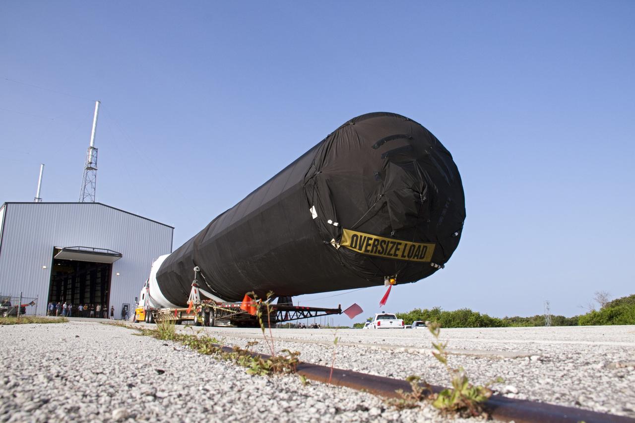 CAPE CANAVERAL, Fla. -- At Cape Canaveral Air Force Station in Florida, the first stage of the SpaceX Falcon 9 rocket arrives at Launch Complex-40's horizontal processing hangar. Once assembled, it will be a two-stage fully integrated launch vehicle, consisting of a first stage powered by nine SpaceX-developed Merlin 1C engines, a second stage, an interstage, an unpressurized trunk and the Dragon spacecraft qualification unit.          SpaceX was awarded procurement for three demonstration flights under the Commercial Orbital Transportation Services, or COTS, program managed by NASA's Johnson Space Center in Houston. A subsequent contract for Commercial Resupply Services, or CRS, was awarded in late 2008 to resupply the International Space Station. The SpaceX CRS contract provides for 12 missions to resupply the station from 2011 through 2015. Photo credit: NASA/Troy Cryder
