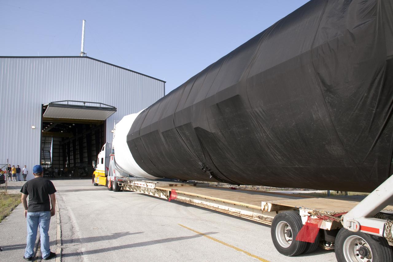 CAPE CANAVERAL, Fla. -- At Cape Canaveral Air Force Station in Florida, the first stage of the SpaceX Falcon 9 rocket arrives at Launch Complex-40's horizontal processing hangar. Once assembled, it will be a two-stage fully integrated launch vehicle, consisting of a first stage powered by nine SpaceX-developed Merlin 1C engines, a second stage, an interstage, an unpressurized trunk and the Dragon spacecraft qualification unit.          SpaceX was awarded procurement for three demonstration flights under the Commercial Orbital Transportation Services, or COTS, program managed by NASA's Johnson Space Center in Houston. A subsequent contract for Commercial Resupply Services, or CRS, was awarded in late 2008 to resupply the International Space Station. The SpaceX CRS contract provides for 12 missions to resupply the station from 2011 through 2015. Photo credit: NASA/Troy Cryder