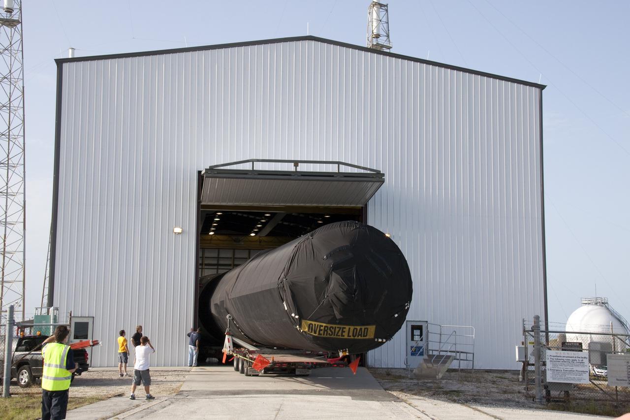 CAPE CANAVERAL, Fla. -- At Cape Canaveral Air Force Station in Florida, the first stage of the SpaceX Falcon 9 rocket arrives at Launch Complex-40's horizontal processing hangar. Once assembled, it will be a two-stage fully integrated launch vehicle, consisting of a first stage powered by nine SpaceX-developed Merlin 1C engines, a second stage, an interstage, an unpressurized trunk and the Dragon spacecraft qualification unit.          SpaceX was awarded procurement for three demonstration flights under the Commercial Orbital Transportation Services, or COTS, program managed by NASA's Johnson Space Center in Houston. A subsequent contract for Commercial Resupply Services, or CRS, was awarded in late 2008 to resupply the International Space Station. The SpaceX CRS contract provides for 12 missions to resupply the station from 2011 through 2015. Photo credit: NASA/Troy Cryder