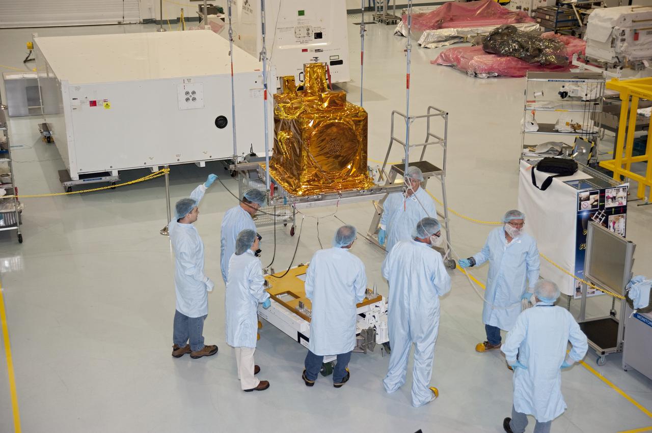 CAPE CANAVERAL, Fla. -- As the lift of the Space Test Program-Houston-3, or STP-H3, payload begins in the Space Station Processing Facility at NASA Kennedy Space Center in Florida, workers inspect the bottom surface of the platform for sharp edges and cleanliness, prior to installation onto the Express Logistics Carrier-3, or ELC-3.          STP-H3 is a compliment of four individual Department of Defense experiments that will test concepts in low earth orbit for long duration flights. As the final planned mission of the Space Shuttle Program, shuttle Endeavour and its STS-134 crew will deliver the Alpha Magnetic Spectrometer, the ELC-3 as well as critical spare components to the International Space Station. Endeavour is targeted for launch Feb. 26, 2011. For more information visit, http://www.nasa.gov/mission_pages/shuttle/shuttlemissions/sts134/index.html. Photo credit: NASA/Kim Shiflett
